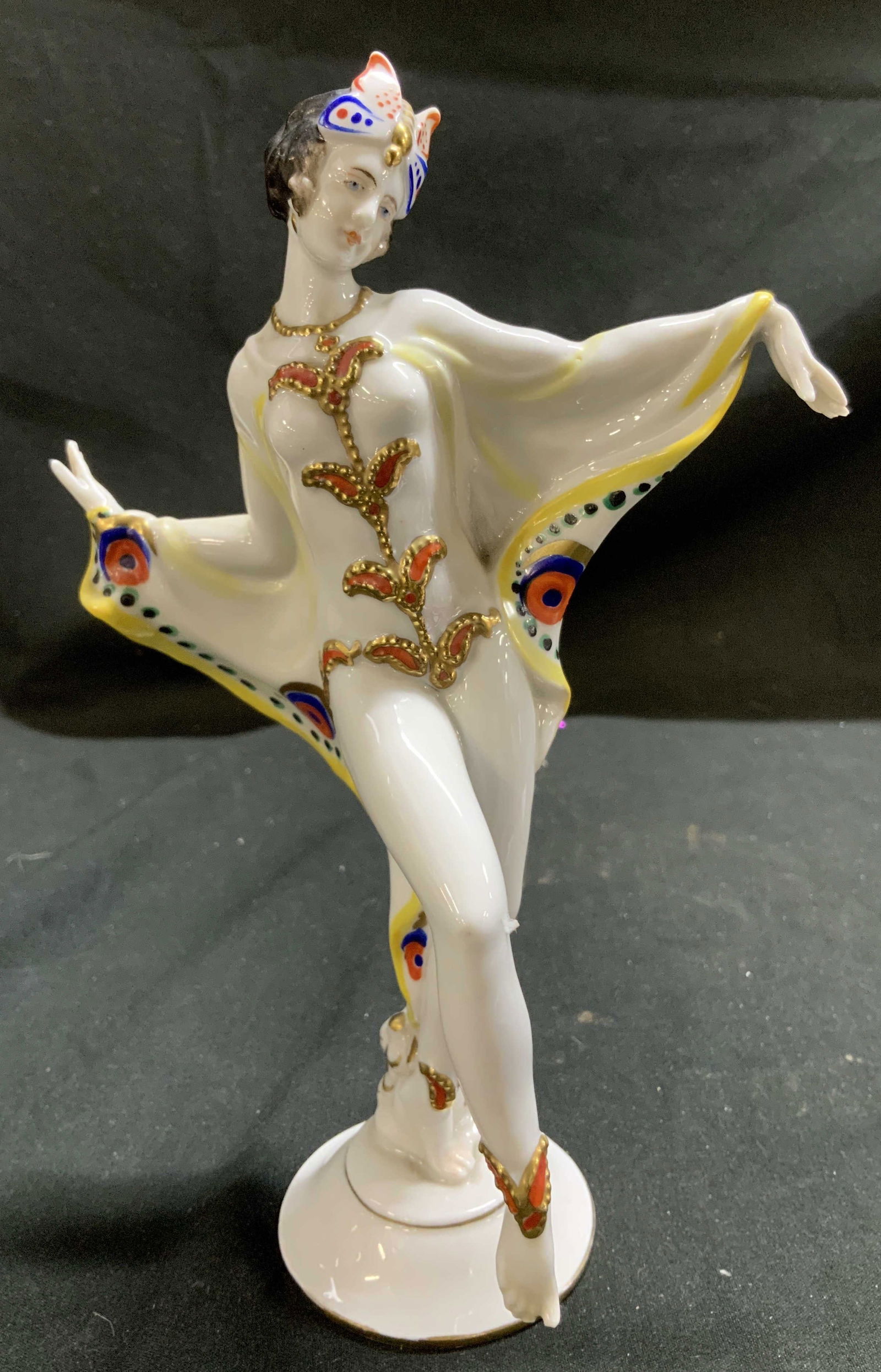 Vntg CAPODIMONTE Art Deco Dancer Porc Figurine: Figurine is porcelain material & depicts a dancer in a theatrical costume. Figure features vibrant colors & intricate detailing. Dancer has a butterfly motif on her head. Signed & marked on underside.