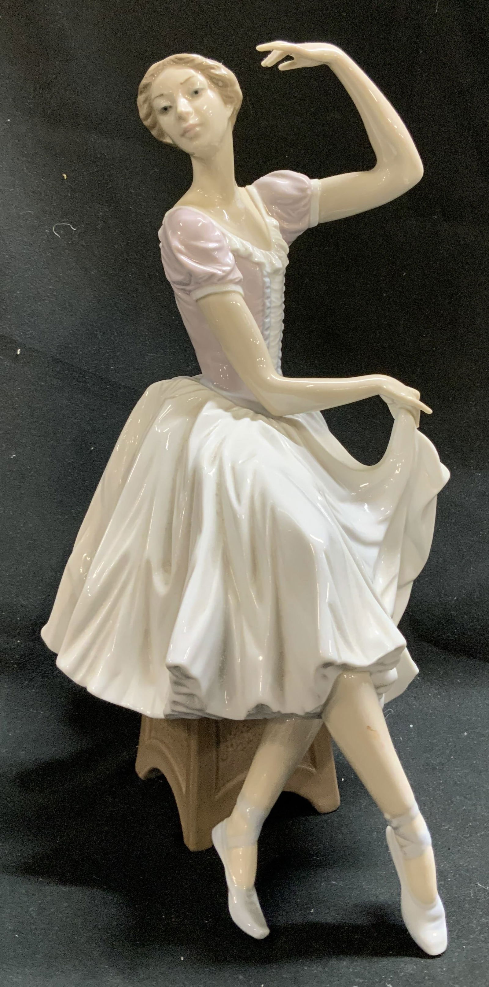 LLADRO Weary Ballerina Porcelain Figurine SPAIN: LLADRO Weary Ballerina Porcelain Figurine SPAIN Porcelain figurine depicting a ballerina in a resting pose, seated with one arm raised and the other holding her skirt. Signed & marked. Reads, LLADRO H
