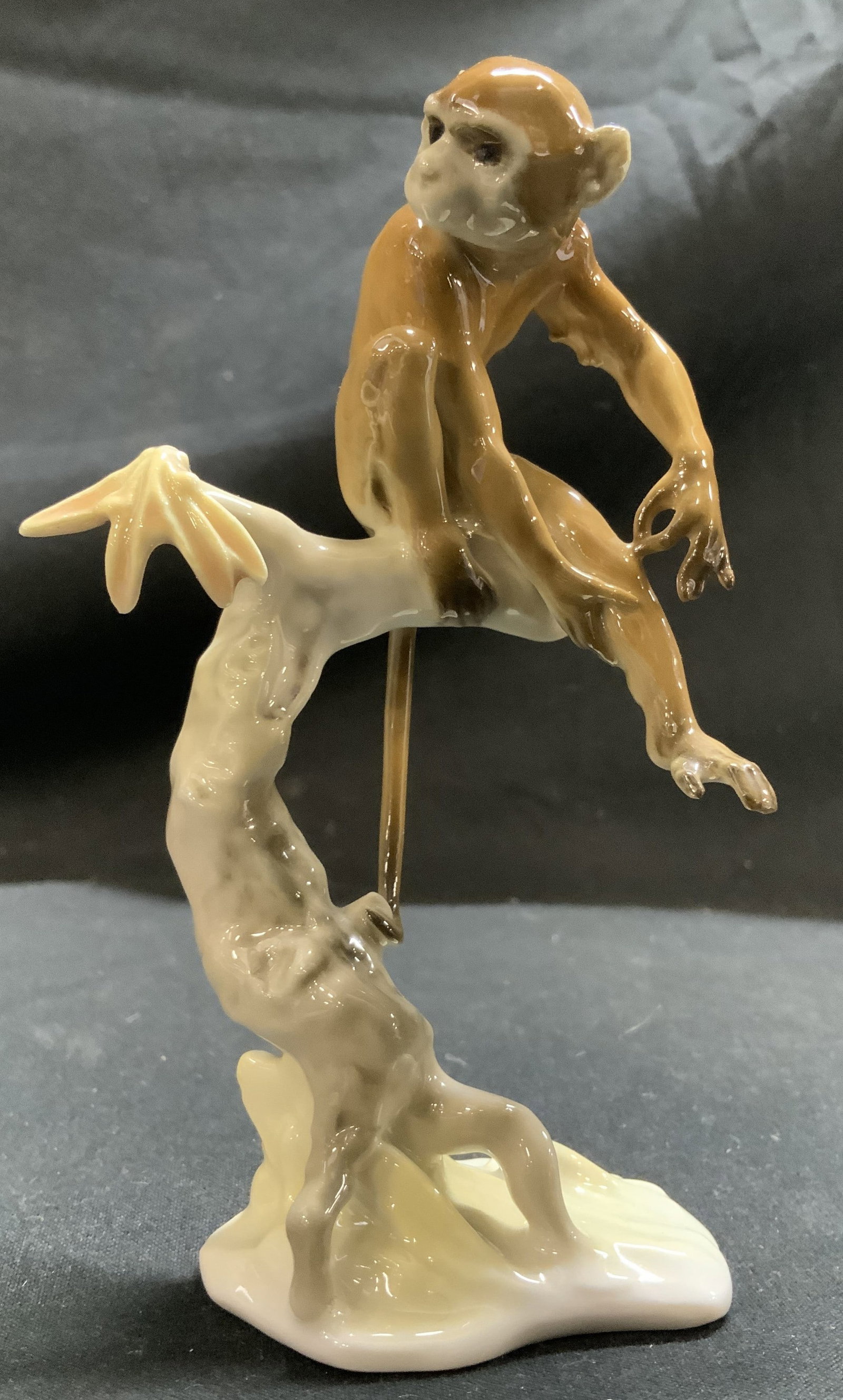 Vntg Hutschenreuther Monkey Porc Fig. GERMANY: Porcelain figurine depicts a brown monkey perched on a tree branch. Figurine features a glossy finish. Signed & marked on underside. Reads, Hutschenreuther GERMANY. Surface wear consistent to age, use