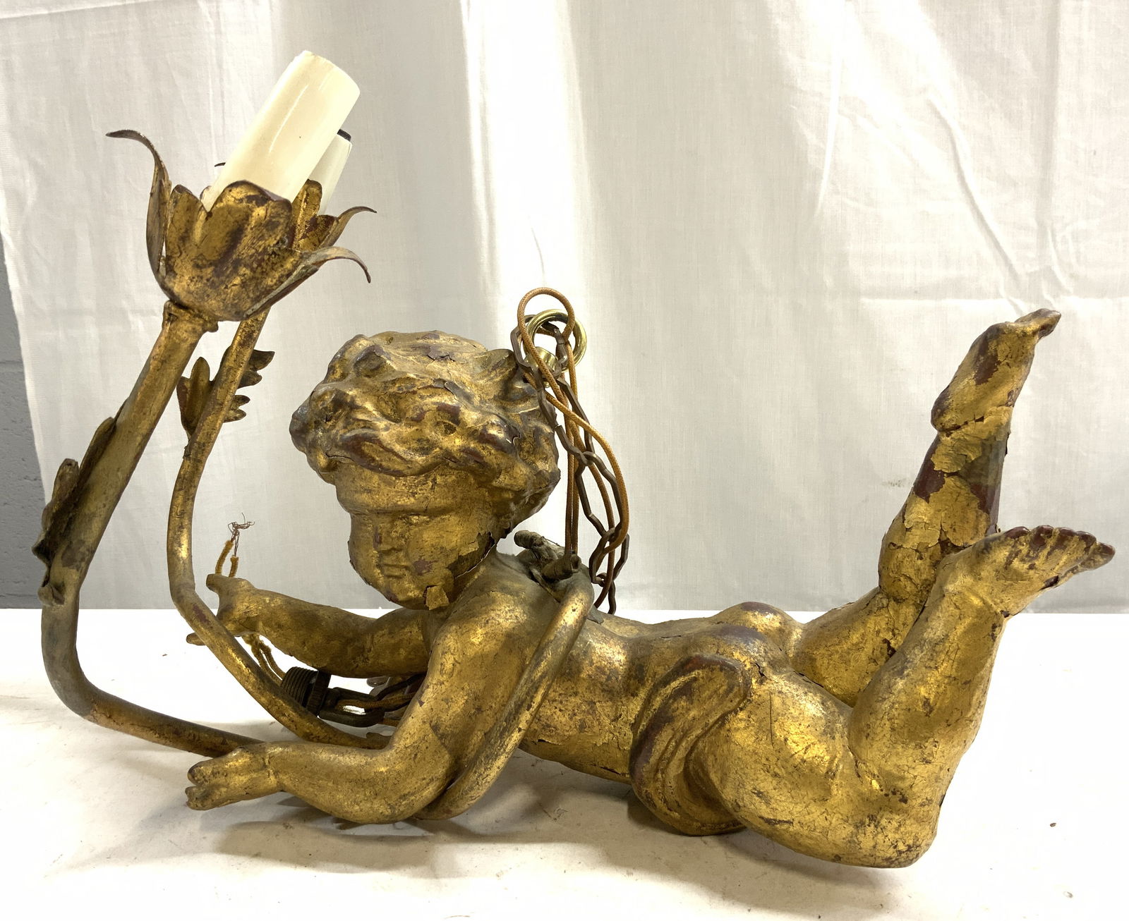 Vtg Giltwood & Metal 2 Arm Cherub Chandelier: Chandelier is vintage. Piece has gilt wood cherub figure & 2 gilt metal arms with candlestick style bulb sockets at ends. Chandelier has chain link. Lot includes ceiling cap. Arms have leaf structures