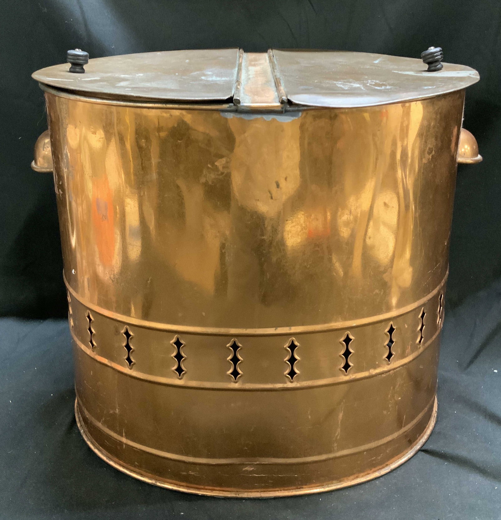 Vntg Cylindrical Copper Lidded Coal Scuttle: Vntg Cylindrical Copper Lidded Coal Scuttle Coal scuttle is made of copper material & features a lidded design with a split opening at the top & decorative cut-outs on the middle portion of the coal s