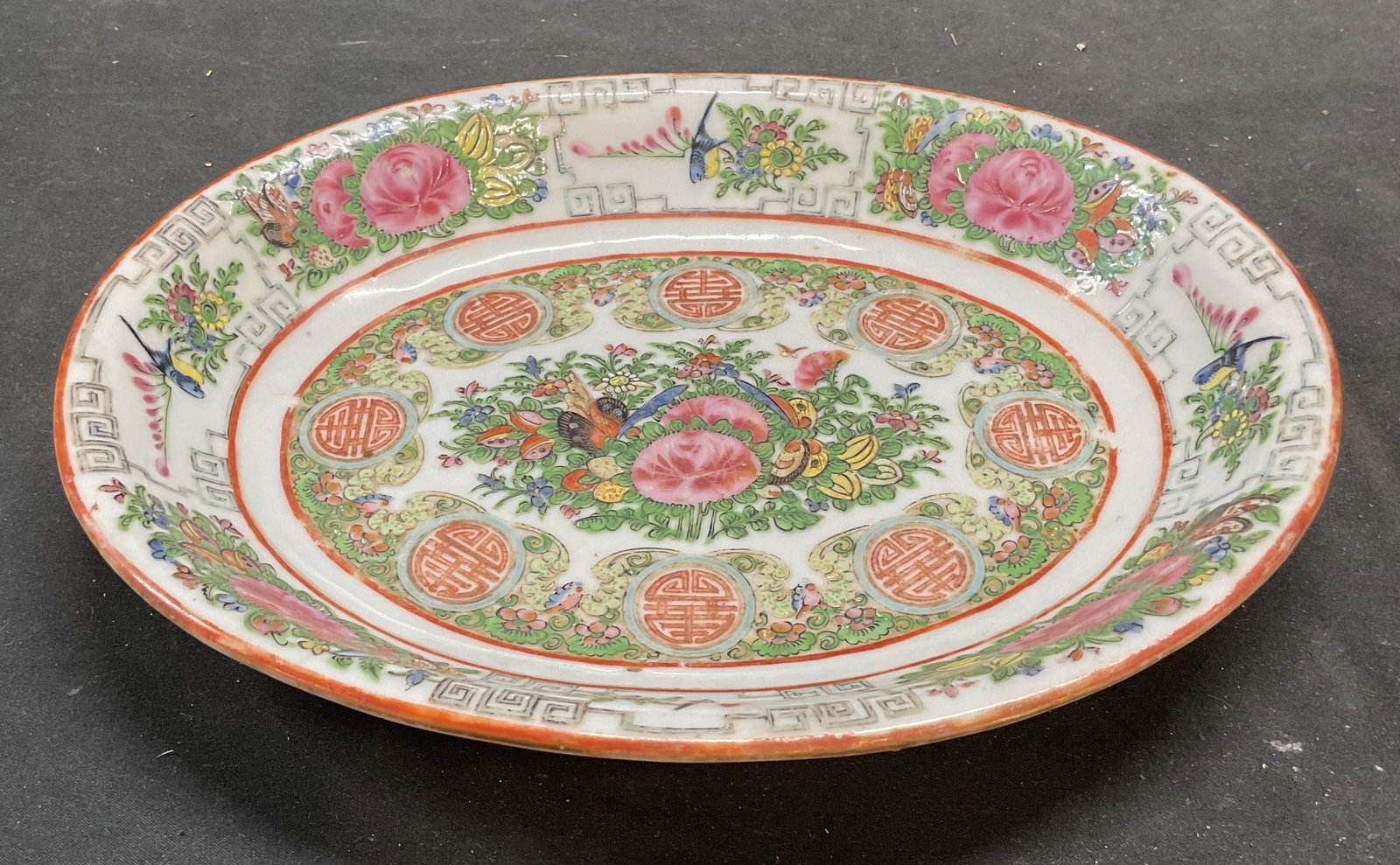 Antique Chinese Rose Medallion Porc Bowl: Antique Chinese Rose Medallion porcelain low rim bowl. Oval shaped. Hand painted famille rose palette of green and pink. Cartouches of tradition Chinese subjects, floral and birds with decorative bord