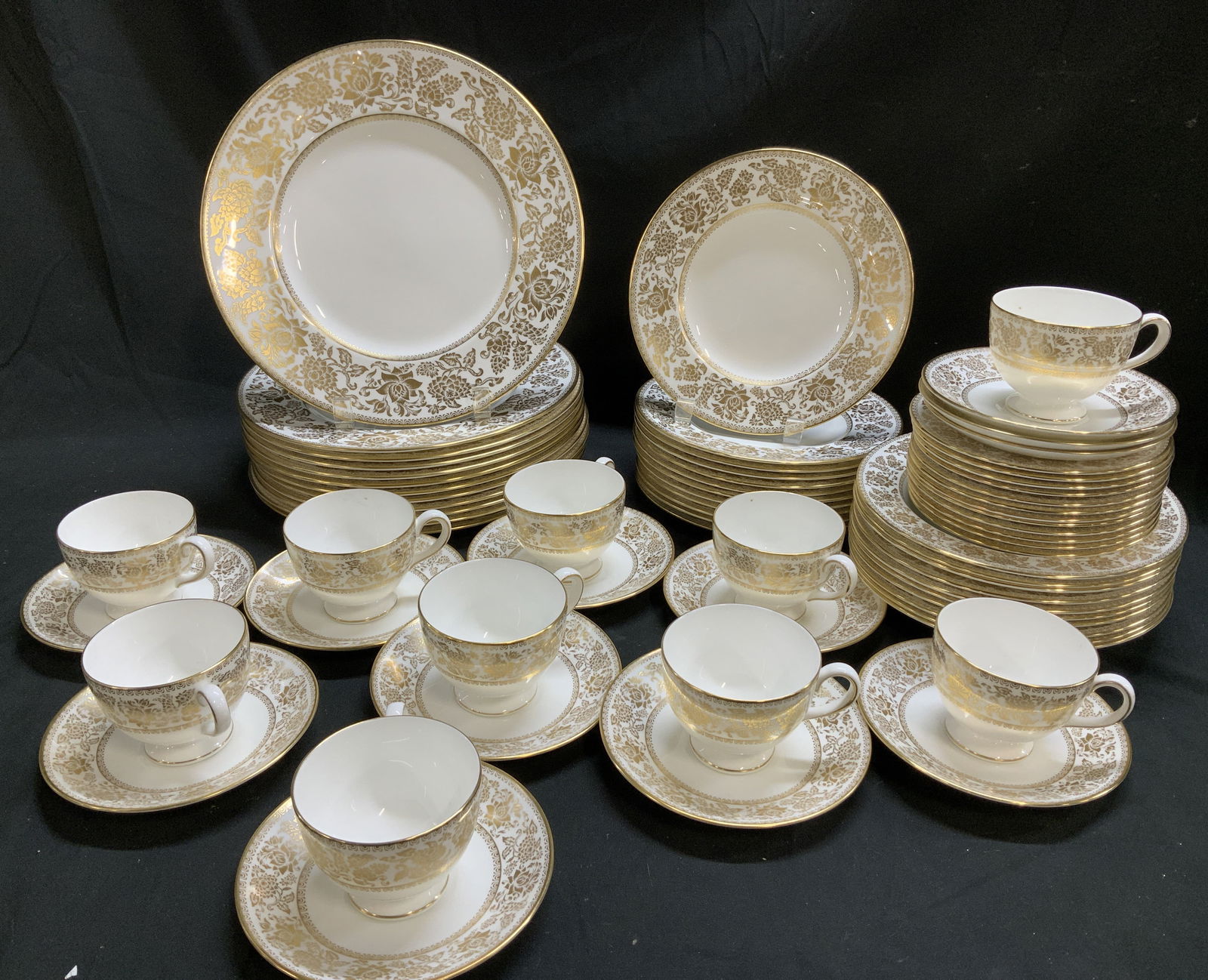 Lot 69 Wedgwood Gold Damask Tableware ENGLAND: Lot includes, 12 dinner plates, 12 salad plates, 12 appetizer plates, 12 saucers, 10 teacups & 11 bowls. Pieces have a distinctive gold damask pattern. Pattern features detailed gold floral/botanical