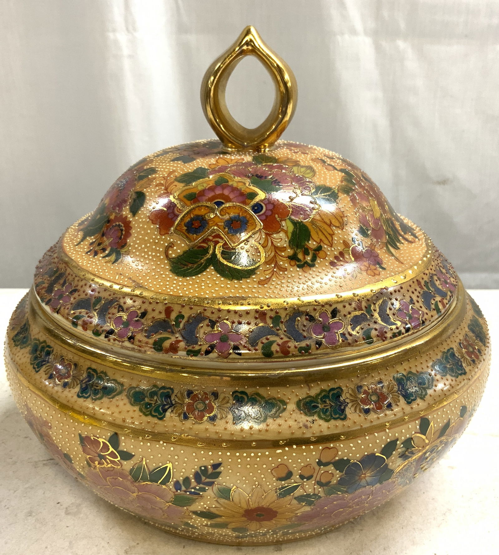 SATSUMA Signed H Painted Asian Porc Lidded Bowl: Underside is signed SATSUMA & has Asian Characters. Bowl is hand painted with intricate multi toned floral & leaf detail. Piece includes lid. Lid has gilt tear drop form handle. Bowl is vintage. Measu