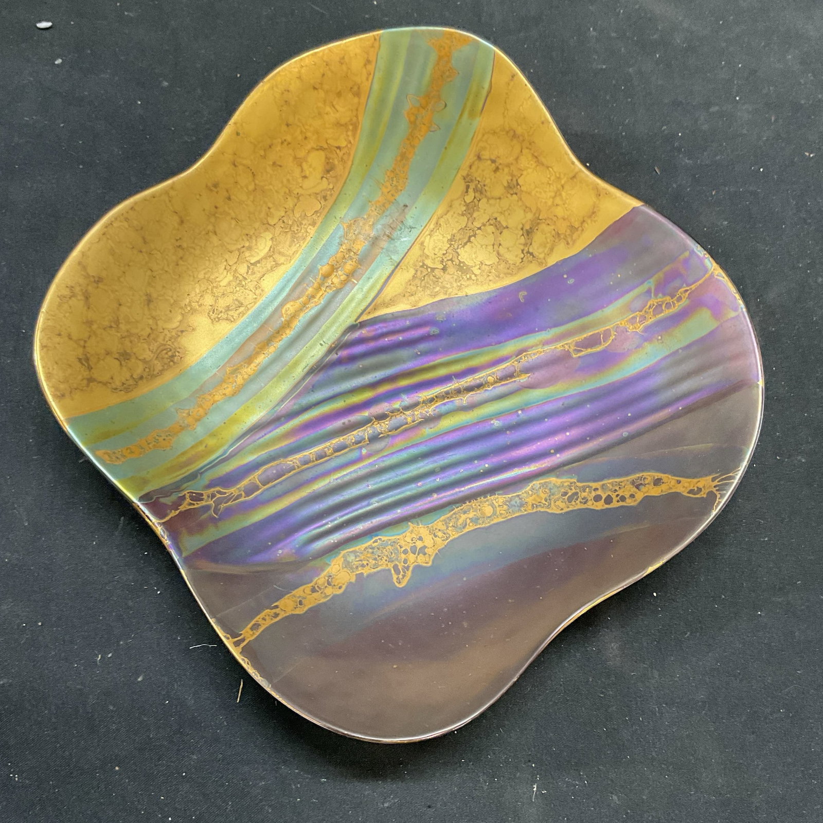 Rosenthal Loon Gilt Porcelain Dish, Germany: Rosenthal porcelain dish. Designed by Johan Van Loon. Signed. Made in Germany. Gilt hand painted abstract banded pattern with iridescent purple and green tones. Scalloped raised rim. Measures approx 7