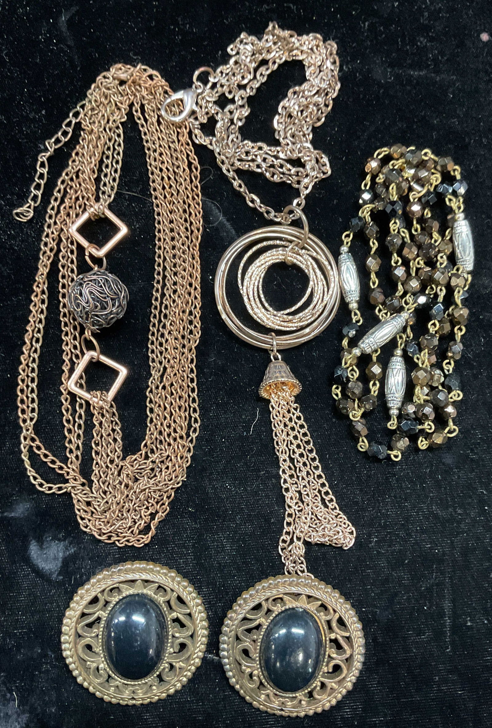 Lot 4 Crystal Necklace, Pendant Necklaces +: Lot of 4 pieces. Gold tone black crystal beaded necklace. Gold tone round pendant and tassel necklace. Gold tone wire ball pendant necklace. Gold tone reticulated earrings and its black lucite cabocho