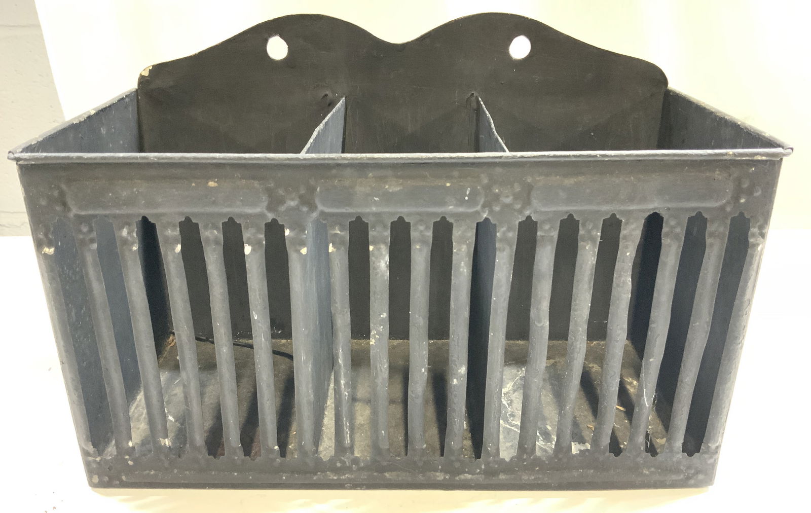 Vintage Divided Metal Wall Pocket: Wall pocket is vintage. Piece is black toned and metal. Wall pocket is divided into 3 separate areas. Holes on backside to mount on wall. Piece measures approximately 10 inches wide 7 inches tall 4 in