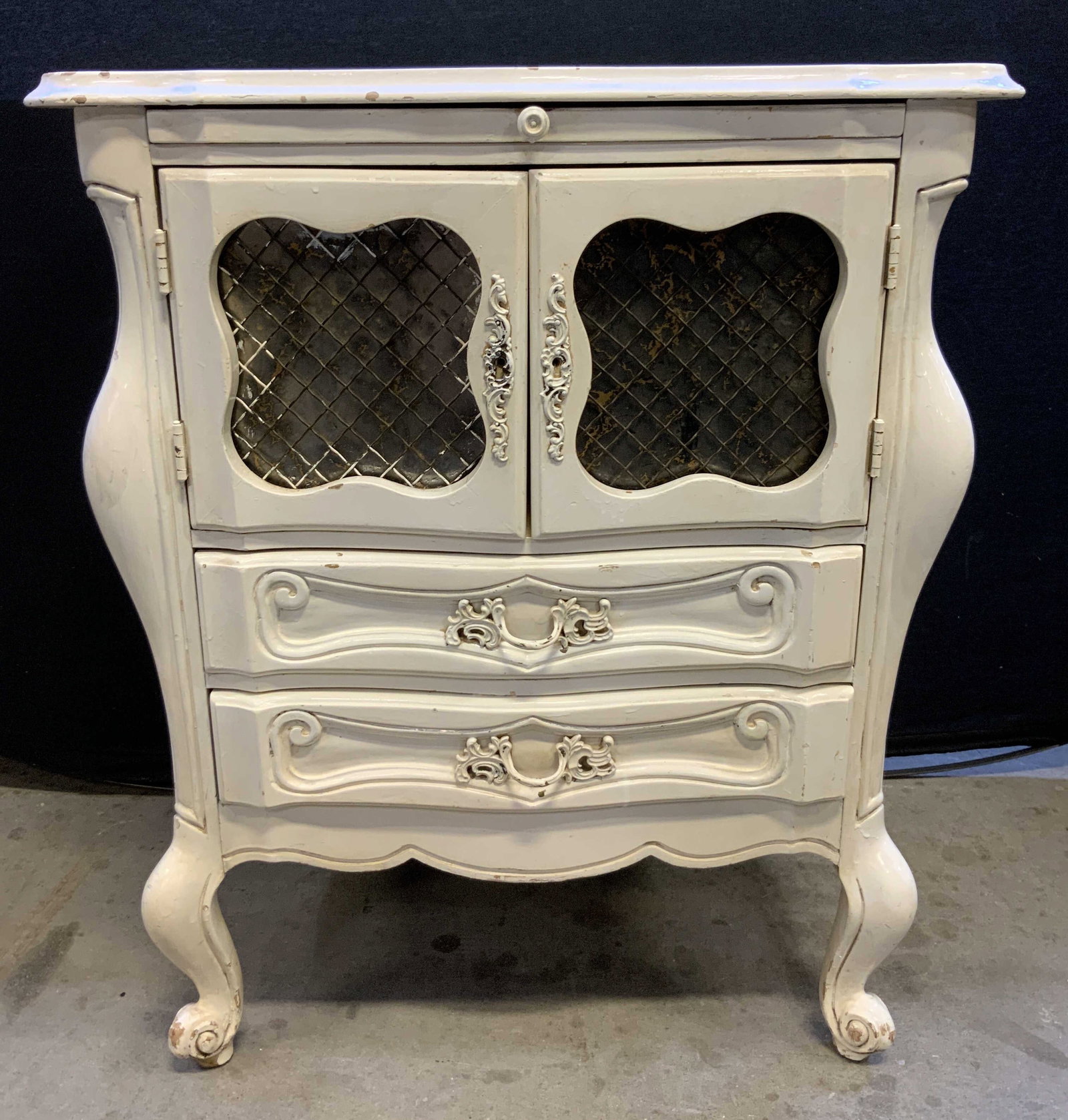 Antq Wooden French Provincial Nightstand White: Nightstand is white Toned and wooden. Piece appears to be antique possibly vintage. French provincial nightstand its double cabinet doors, 2 drawers and pullout board. Piece has 2 curled carved wooden