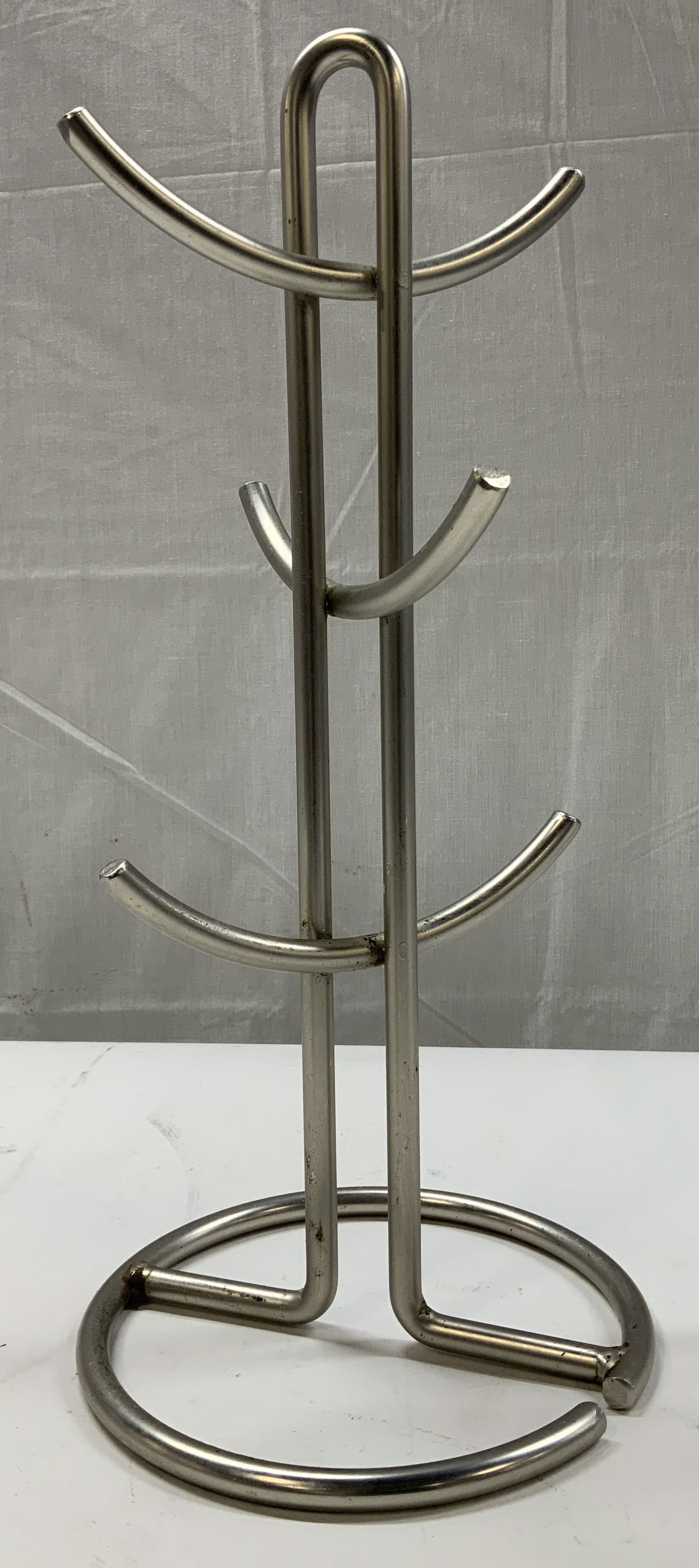 Solid Stainless Steel 6 Mug Holder Stand: Mug holder is designed to hold 6 mugs & is made of stainless steel materials. Mug holder has a solid base & curved arms. Surface wear consistent to age, use & exposure. Measurements: length 7in x widt