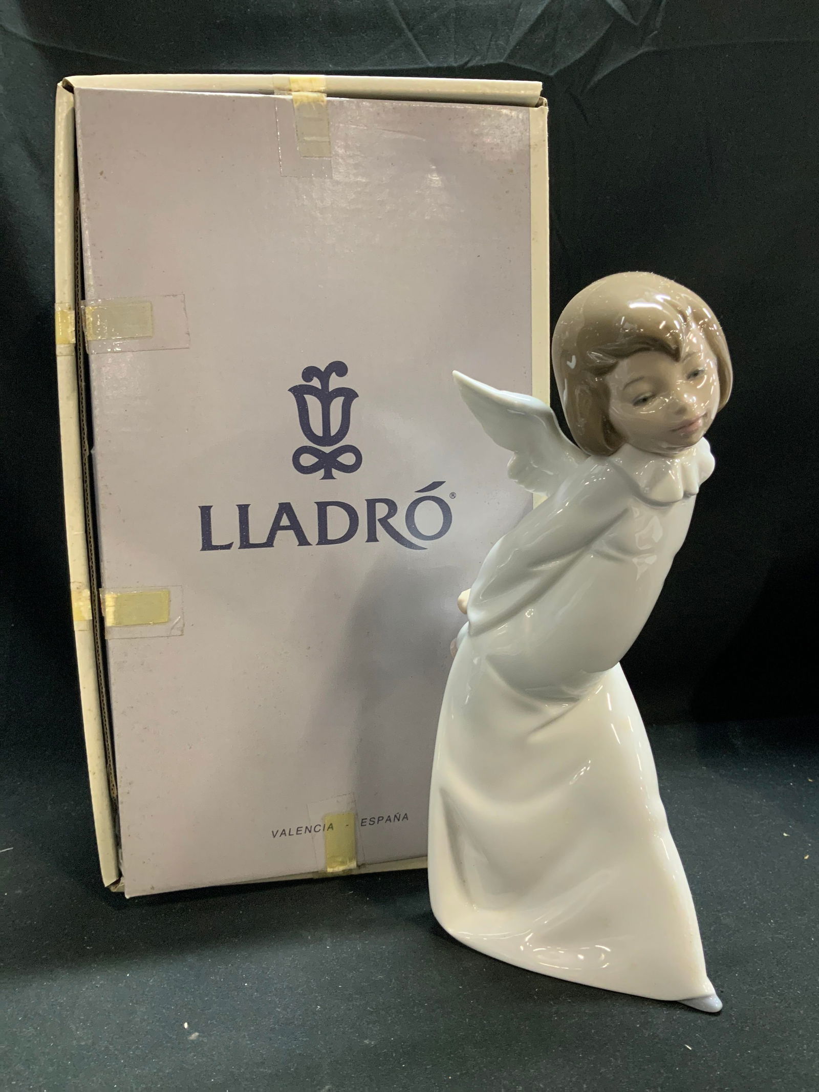 LLADRO Curious Angel Porc Fig. W Box SPAIN: Figurine is porcelain material & depicts an angel with a white robe and wings. The angel is depicted with a curious expression. Comes with original box. Signed & marked on underside. Reads, LLADRO HAN