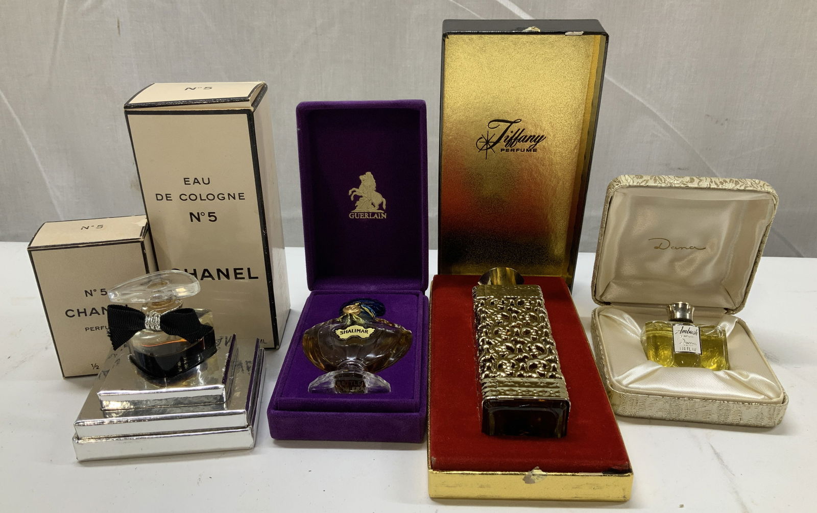 Lot 6 Vntg Assorted Perfumes CHANEL, GUERLAIN+: Lot includes, Tiffany perfume, 2 N5 Chanel perfume (4 FL PZ & 1/2 FL. OZ), Ambush Perfume DANA, Guerlain Paris SHALIMAR & interlude. Perfumes vary in size & shape. Perfumes come with original box or c