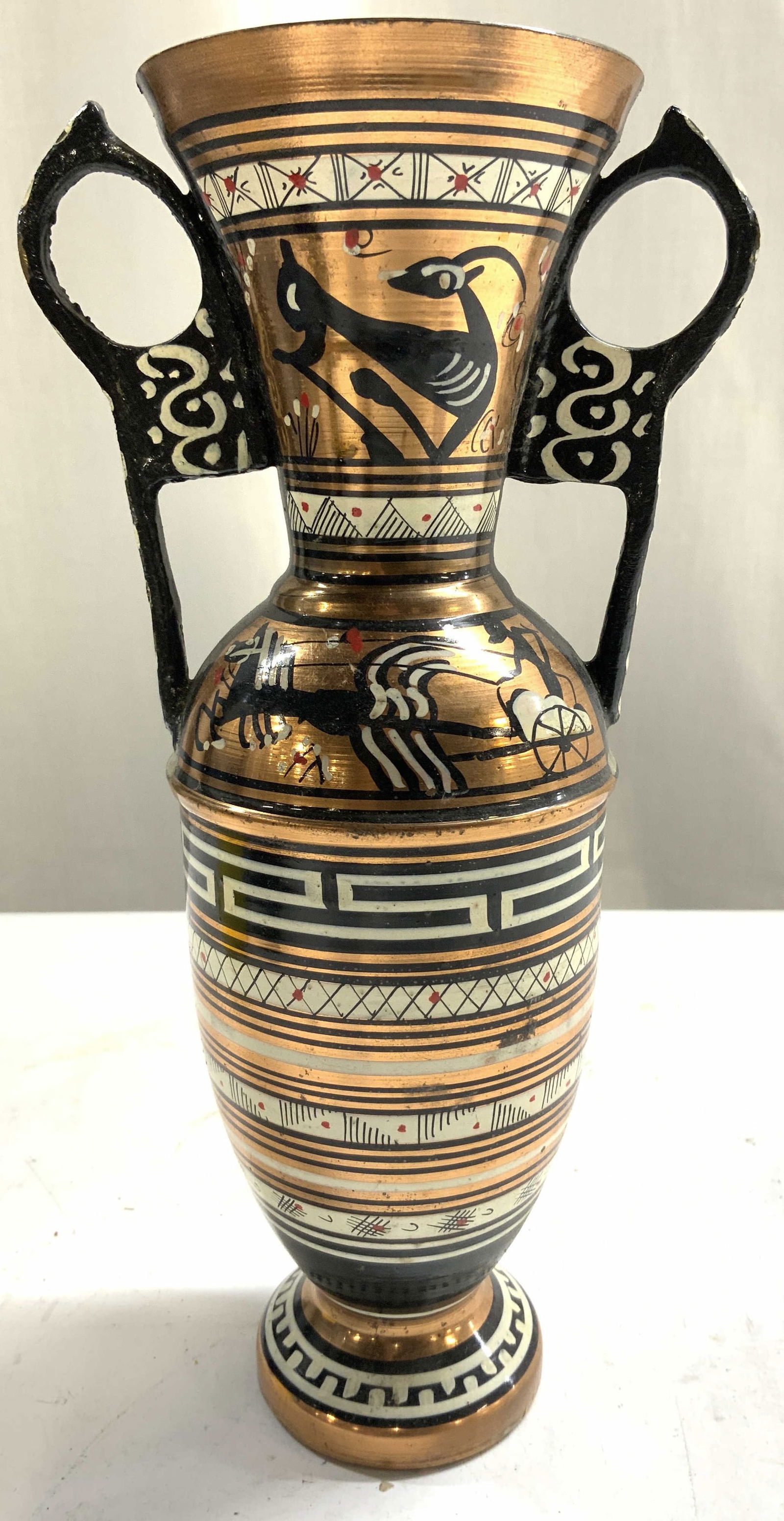 Hand Painted Copper Vase W Handles GREECE: Underside is inscribed HAND MADE IN GREECE. Vessel is copper. Piece is hand painted with stripe, geometric, horse & chariot detail. Vase is footed and has handles at side. Piece measures approximately