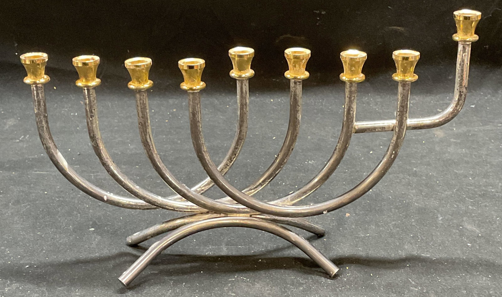 Modernist Silver Tone Curved Menorah Judaica: Modernist style silver and gold tone menorah, curved arms and feet. Measures approx 9 x 2 x 5.25 inches. Some scratching. Menorah, modernist menorah, silver tone menorah, Judaica, holiday accessories,