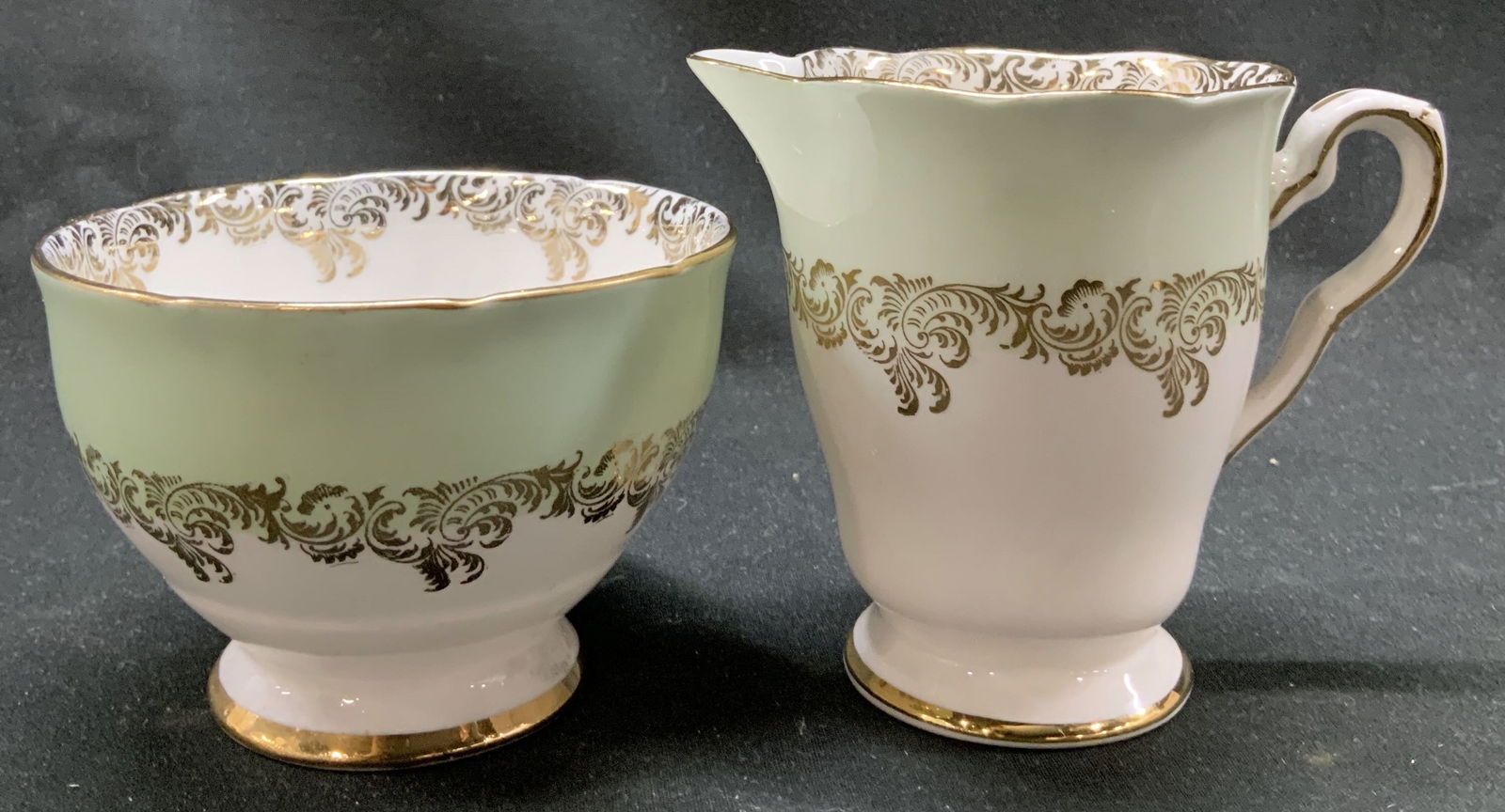 Royal Stafford Bone China Sugar Bwl & Creamer ENG: Royal Stafford Bone China Sugar Bwl & Creamer ENG Lot includes 1 sugar bowl & 1 creamer. They feature a light green upper portion & intricate gold scrollwork detailing. Signed & marked on underside. R