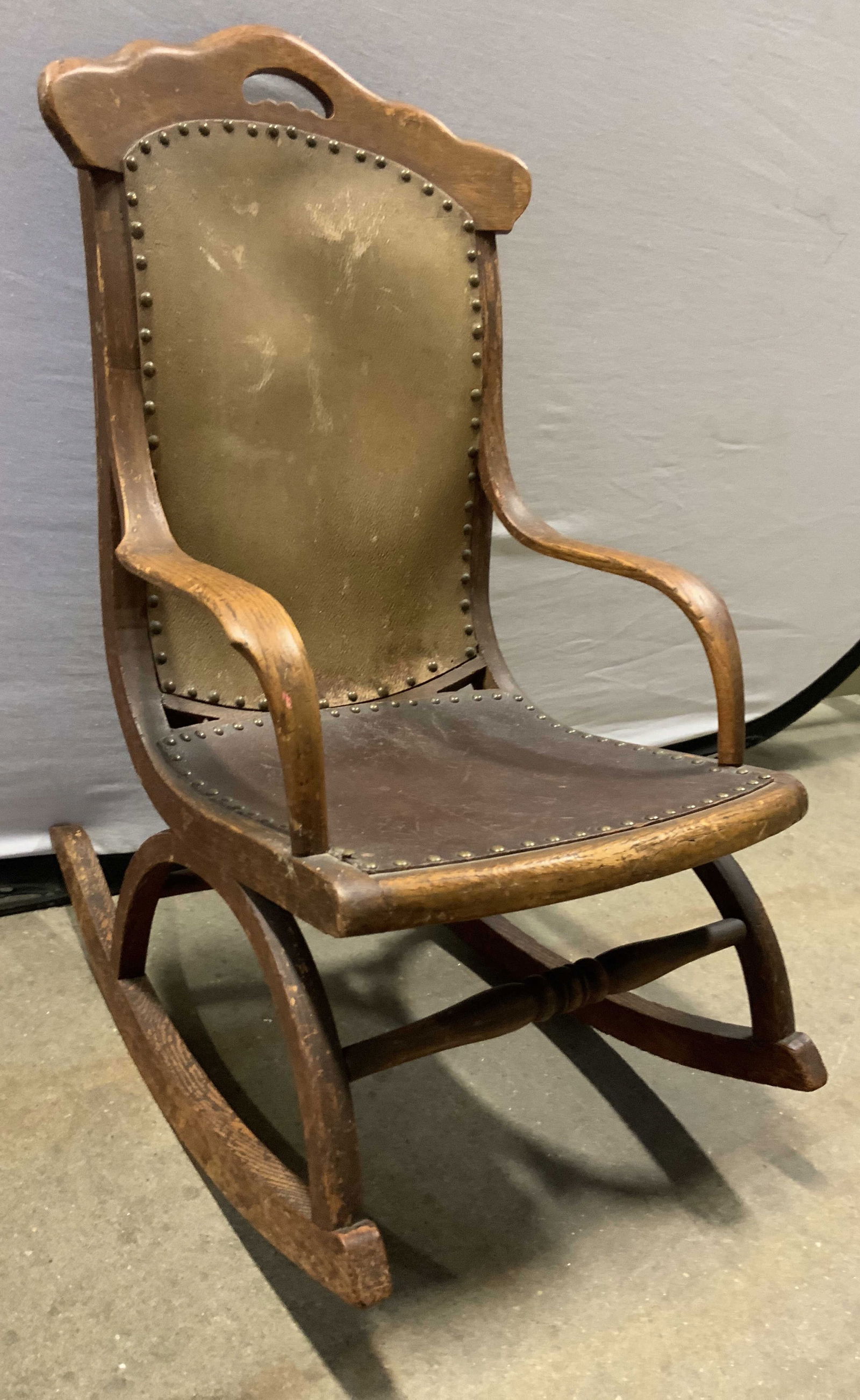 CHARLES A MEAD Spanish Leath & Wd Child Rcking Chr: Tag on Underside reads CHARLES A MEAD. Rocking chair is vintage. Piece has tan & mahogany toned leather upholstered areas with nailhead detailed edges. Rocking chair frame is tan toned & wooden. Chair