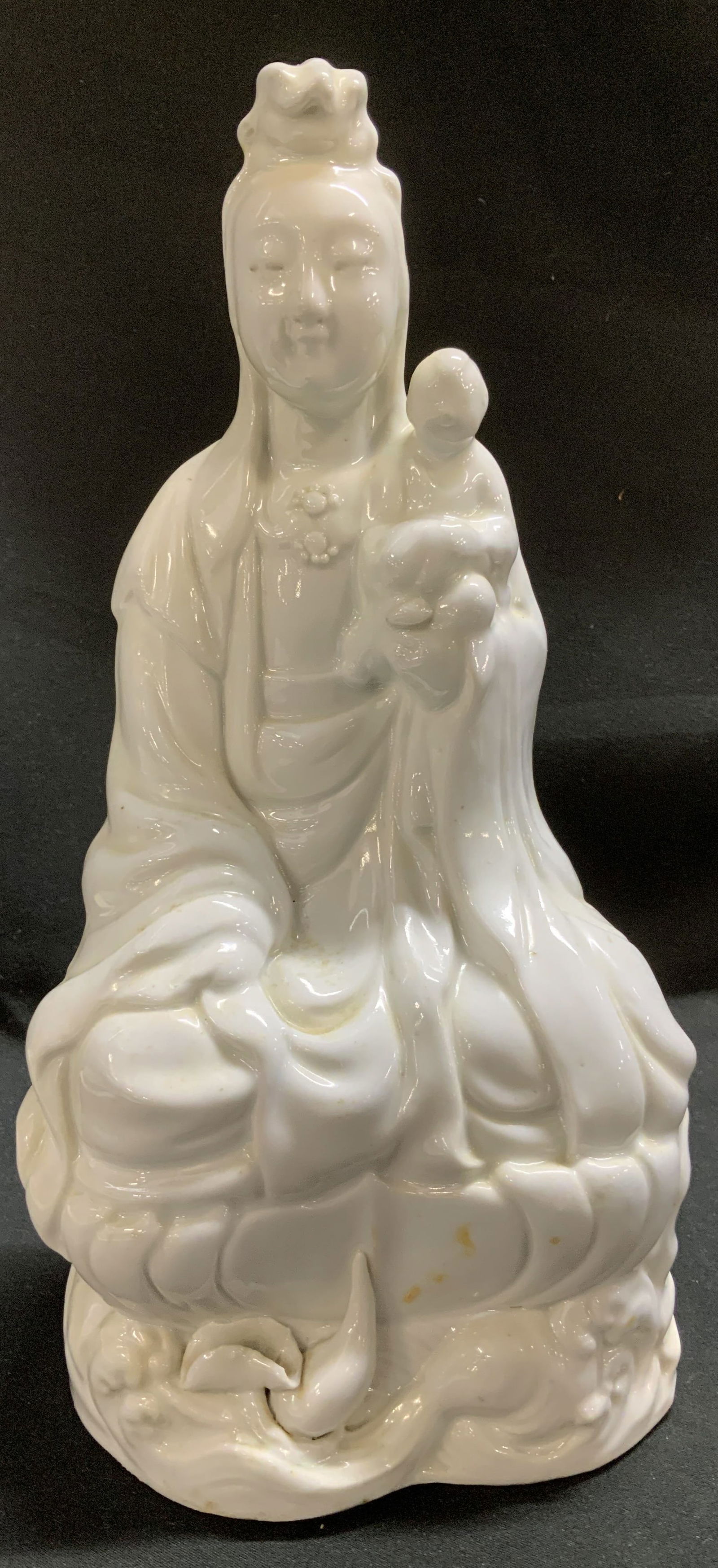 Vntg Blanc De Chine Sitting Guanyin Statue: Statue is porcelain material & depicts Guanyin. A revered figure in East Asian. Figurine is seated & is holding a child. Features a glossy finish. No visible signature or markings. Surface wear consis