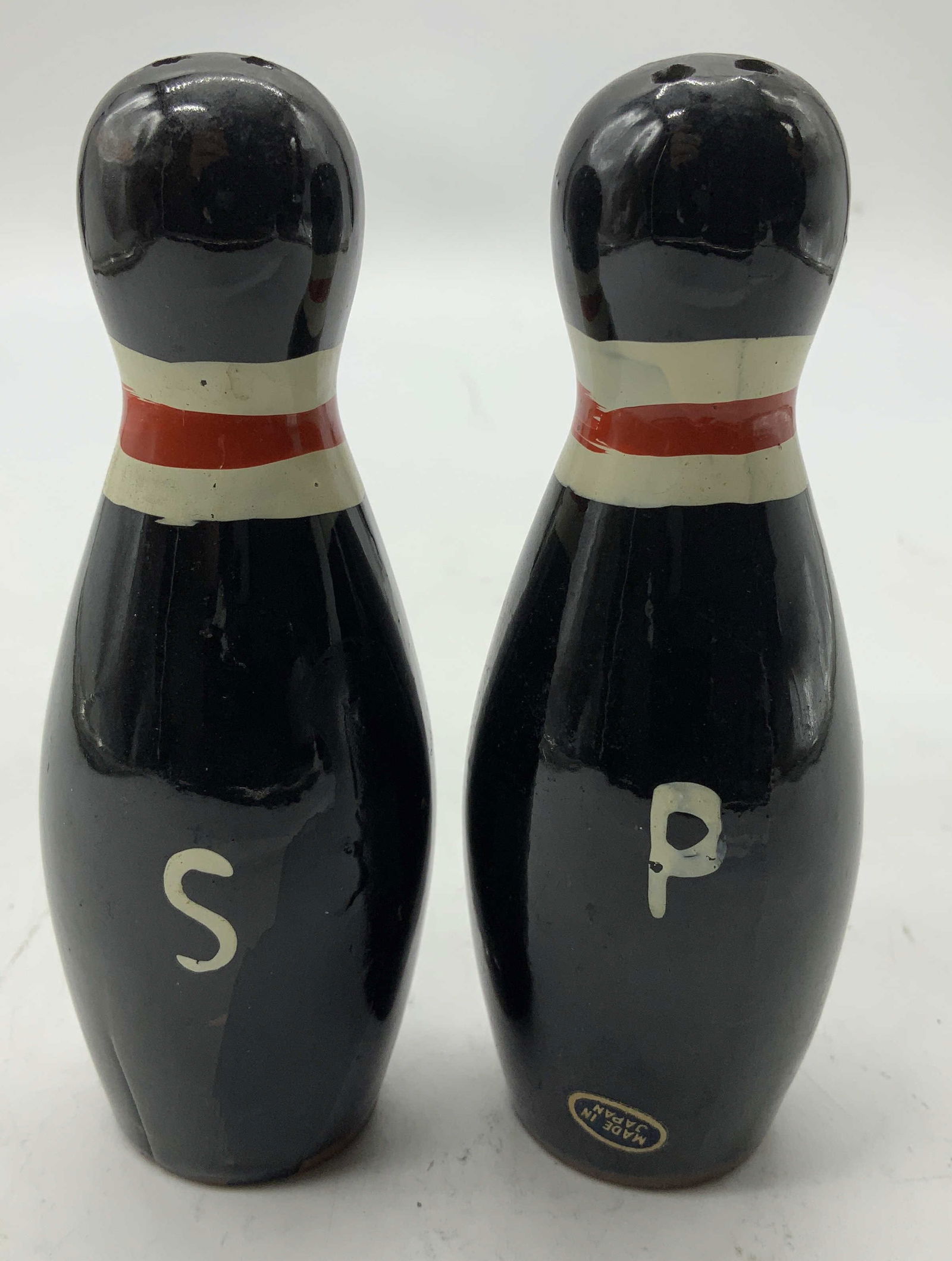 Vntg Bowling Pin Salt & Pepper Shakers JAPAN: Salt & peppers shakers are made of ceramic and are hand-painted in black with a red and white stripe. One shaker has a letter P for pepper, and the other has a letter S for salt. Surface wear consiste