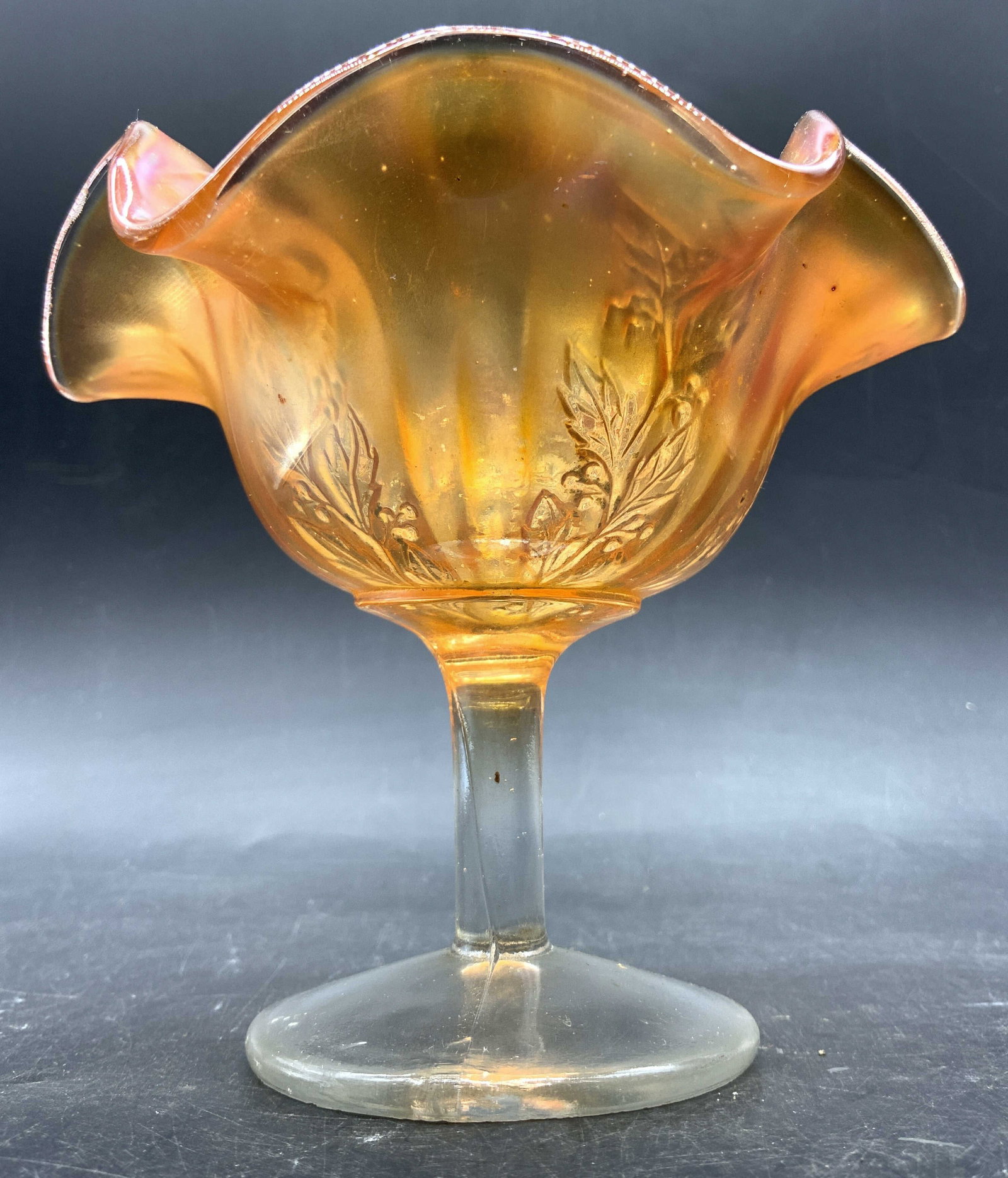 Fenton Vtg Marigold Crnval Gls Cmpte W Ruffled Rim: Compote appears to be FENTON no apparent markings. Piece has marigold tone with iridescent luster. Compote has ruffled rim. Piece has clear stem with circular base. Piece measures approximately 4.25 i