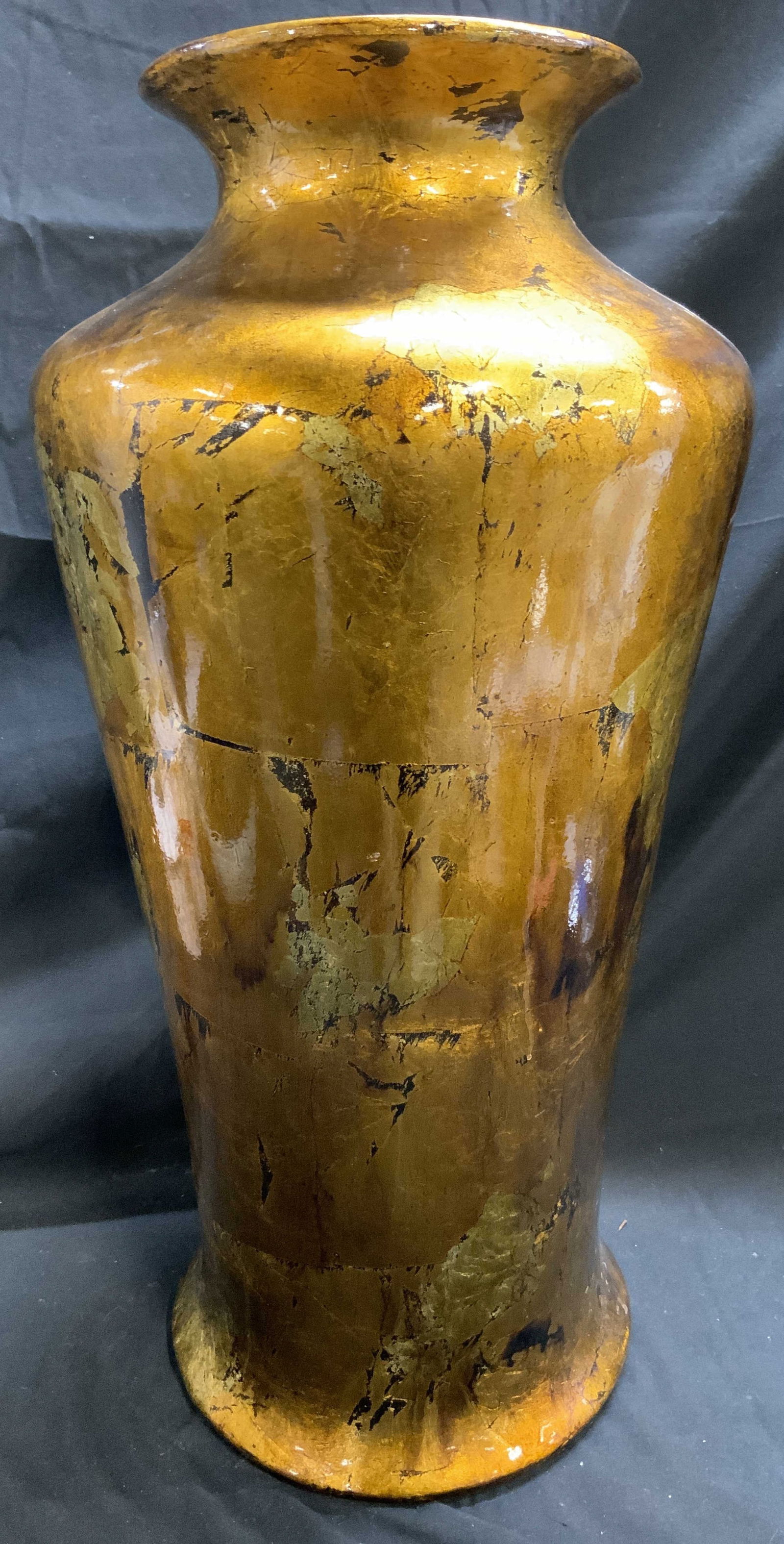 XL Gilt Composite Vase 25 in: Vase appears to be composite, possibly ceramic, possibly plaster. Vase has gold toned gilt and black toned finish. Interior and underside are black toned . Vase rim leans outward. Vase is XL in size m