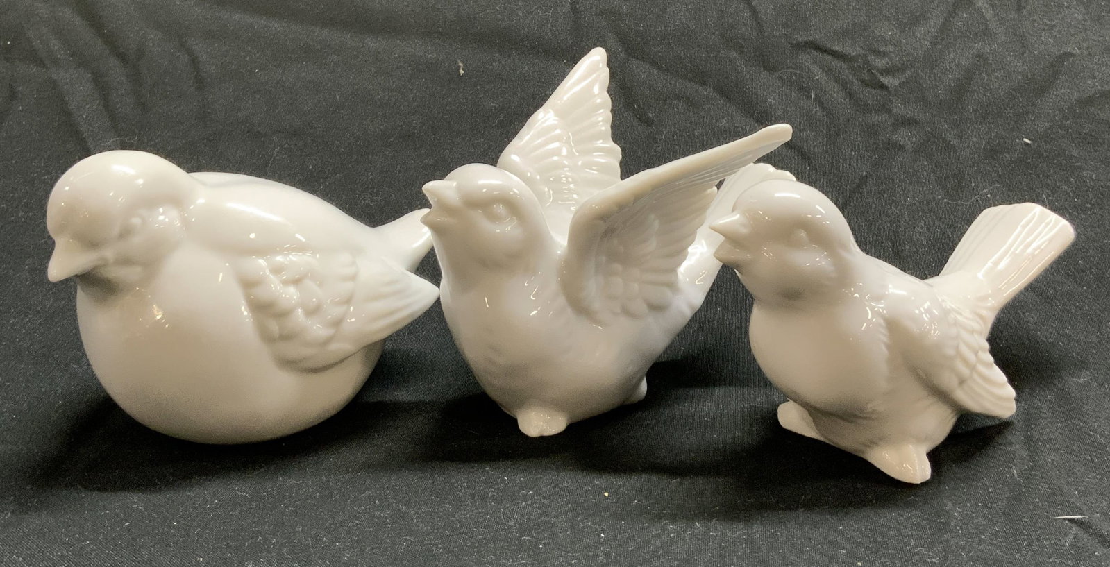 3 Porcelain White Winged Sparrow Bird Figurines: 3 Porcelain White Winged Sparrow Bird Figurines 3 porcelain bird figurines with a glossy look. They appear to be in a resting position & where one bird has their wings raised. Surface wear consistent 