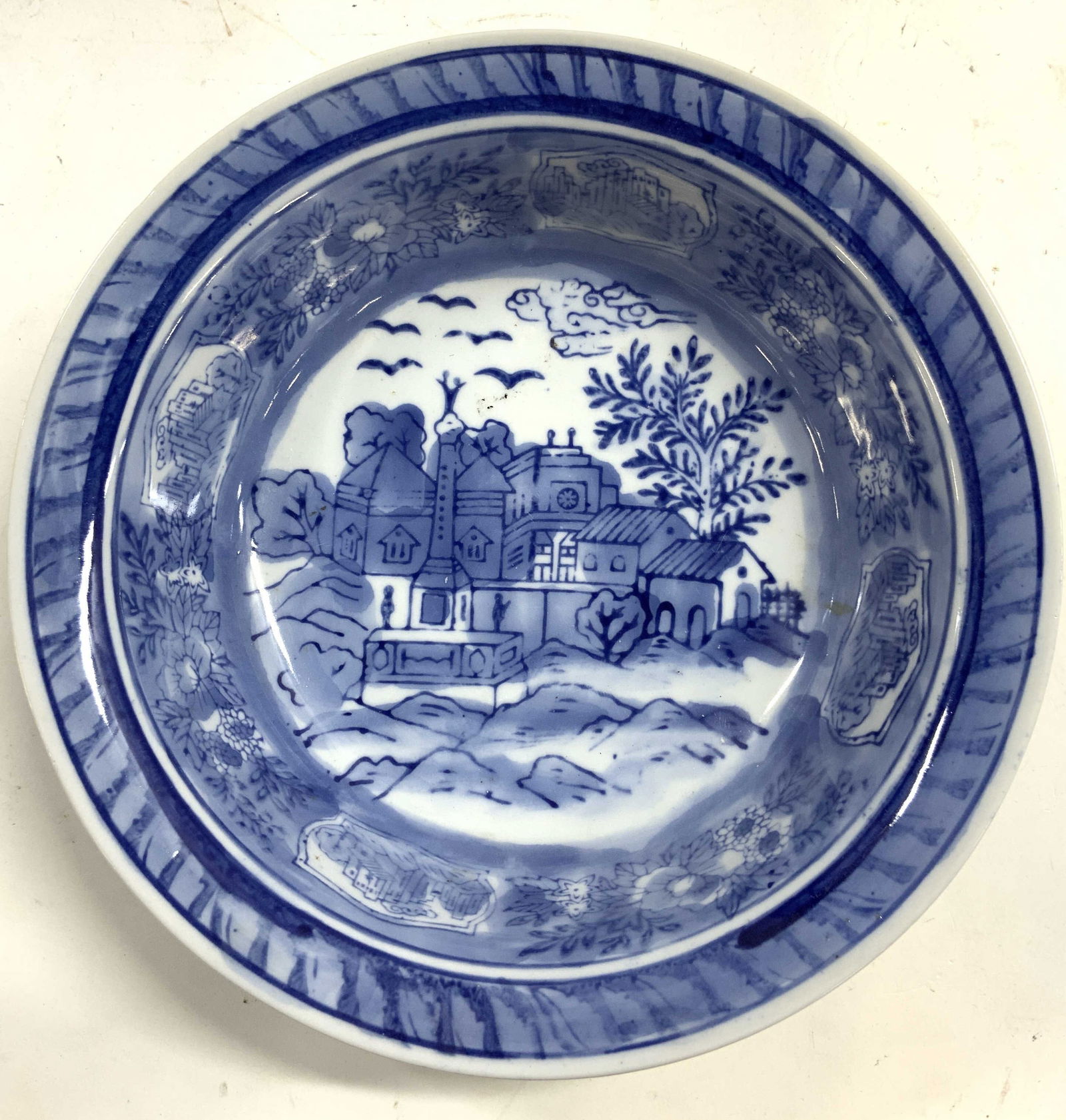 Vintage Asian Porcelain Bowl Vessel: Bowl is vintage. Piece is white with blue toned detail of a village in addition to floral and leaf detail. Bowl rim leans outward. Bowl measures approximately 8 inches diameter 2.25 inches tall. Bowl,