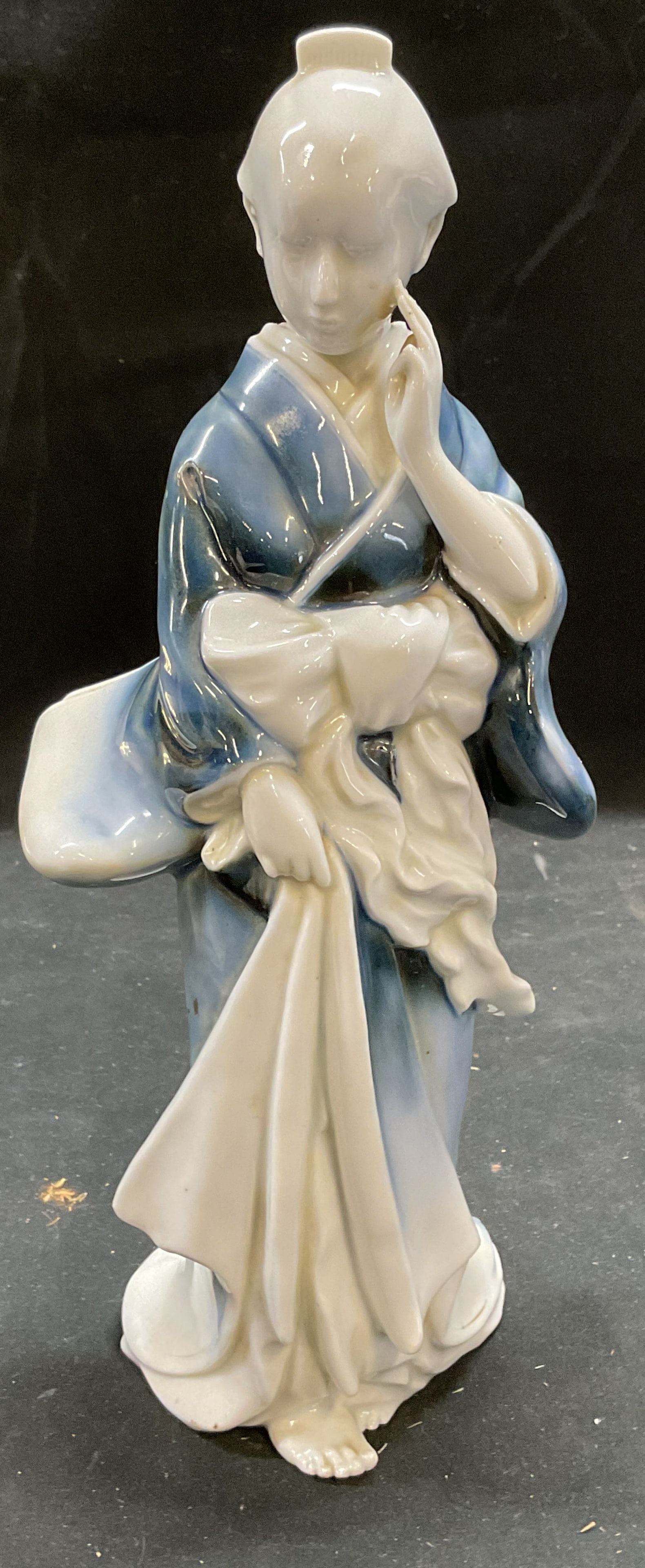 Signed Asian Porcelain Woman Figurine: Signed Ariana porcelain figurine depicting a woman. Signed on underside. Woman in robe, blue and white. Measures approx 4 x 4 x 10.5 inches. Some wear consistent with exposure. Asian figurine, woman f
