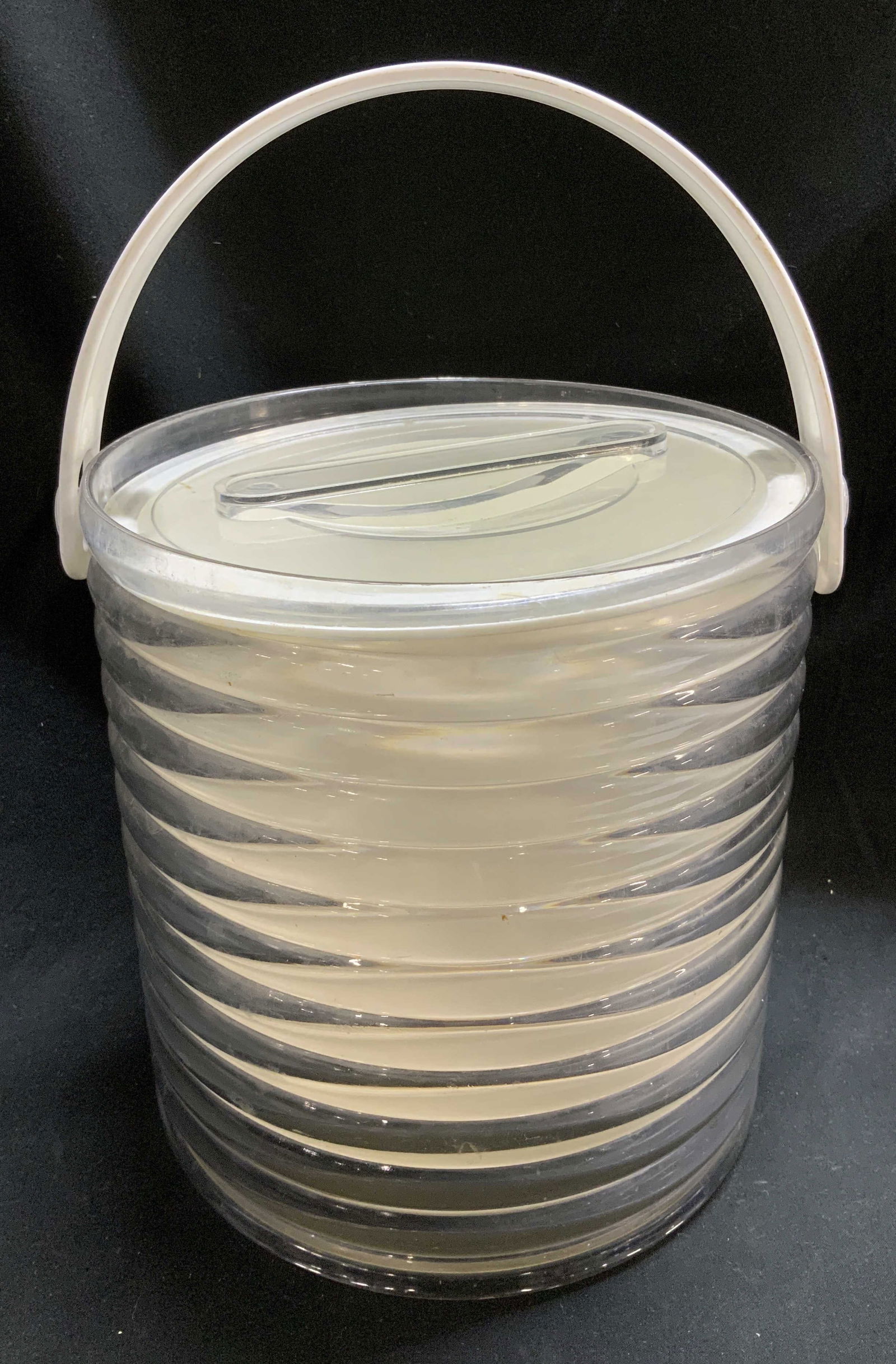 Vntg Sally Design Clear Ribbed Ice Bucket USA: Ice bucket is vintage & features a clear acrylic with a white interior liner and handle. It features a distinctive ribbed texture on the exterior. Clear lid & comes w tongs. Signed & marked on undersi