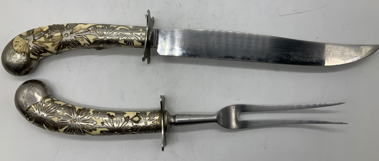 Vtg Judson Stainless Sheffield Carving Set ENGLAND: Carving set includes, carving knife & two pronged fork. Pieces are stainless & material. Feature a floral motif handle. Handle appears to be possible bone material. Signed & marked on underside. Reads