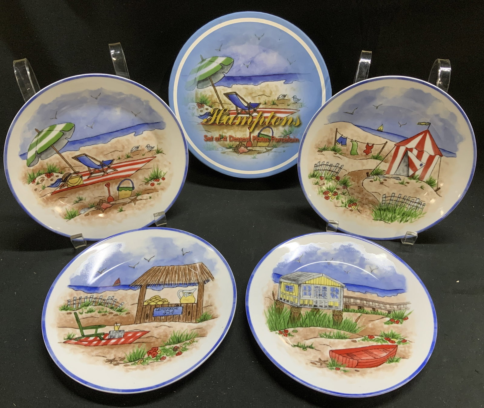 I.Godinger Hamptons Set of 4 Dessert Porc Plates: Porcelain dessert plates with a beach scene design. It is part of the Hamptons Beach Scenes set by I. Godinger. Plates are hand-painted & feature a blue rim. Surface wear consistent to age, use & expo