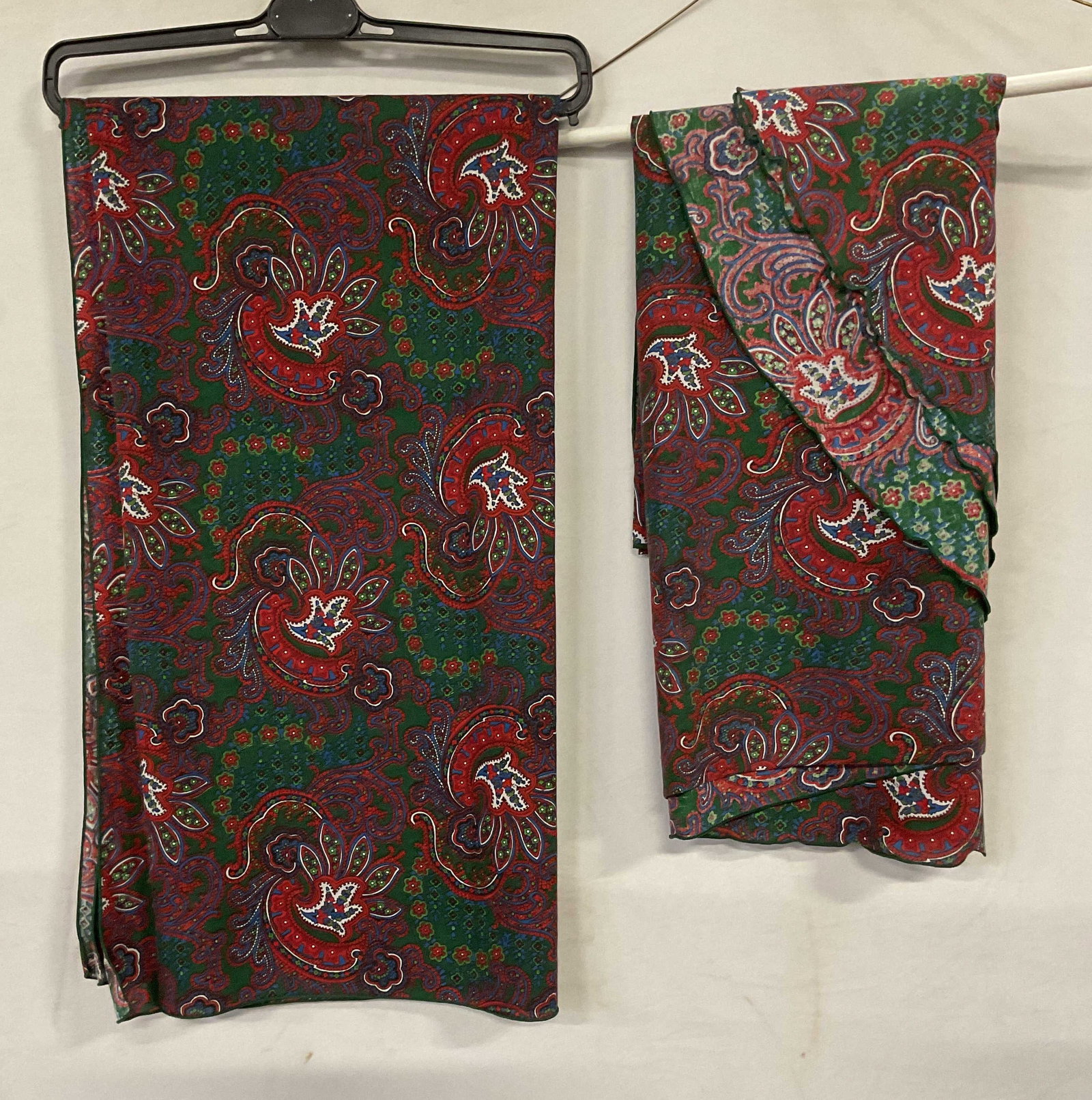 Lot 2 Oval & Rectangle Paisley Print Tablecloths: Lot of 2 oval and rectangle tablecloths with matching paisley print in green and red. Feels like cotton. Oval tablecloth measures approx 70 inches wide. Rectangle tablecloth measures approx 54 x 51 in