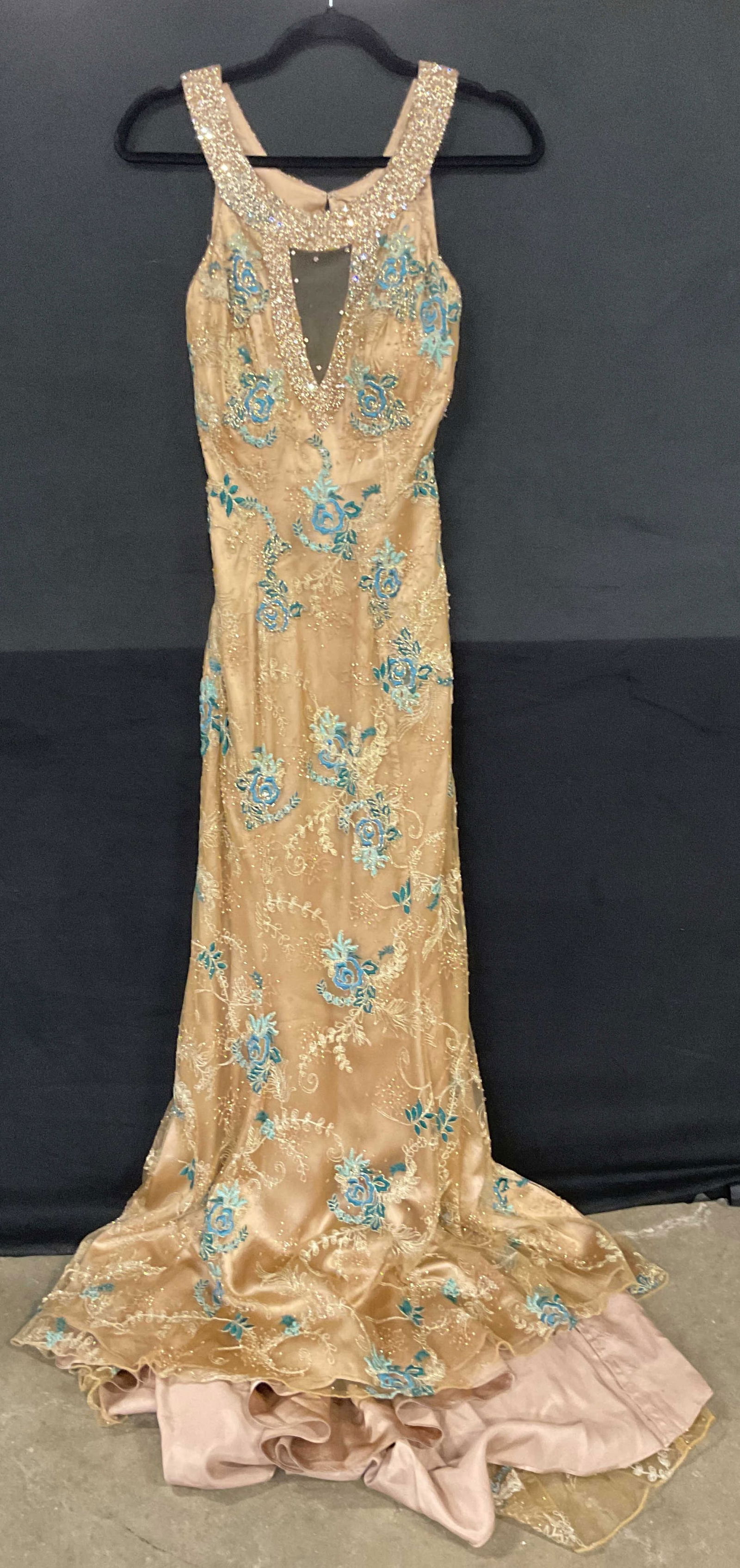 Claires Collection Tan Blue Beaded Gown: Claires Collections tan sleeveless gown with blue embroidered floral design and beading. All polyester. Lined. Measures approx 12 inches across chest, 11 inches below bust. Material has no stretch. So