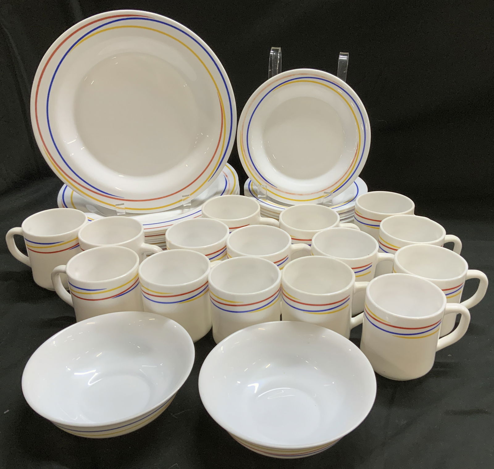 Lot 44 ARCOPAL Milk Glass Tableware FRANCE: Lot includes, 14 cups, 2 bowls, 15 salad plates & 13 dinner plates. Pieces feature a white milk glass base w a rim decorated with red, yellow & blue bands. Signed & marked on underside. Reads, ARCOPAL