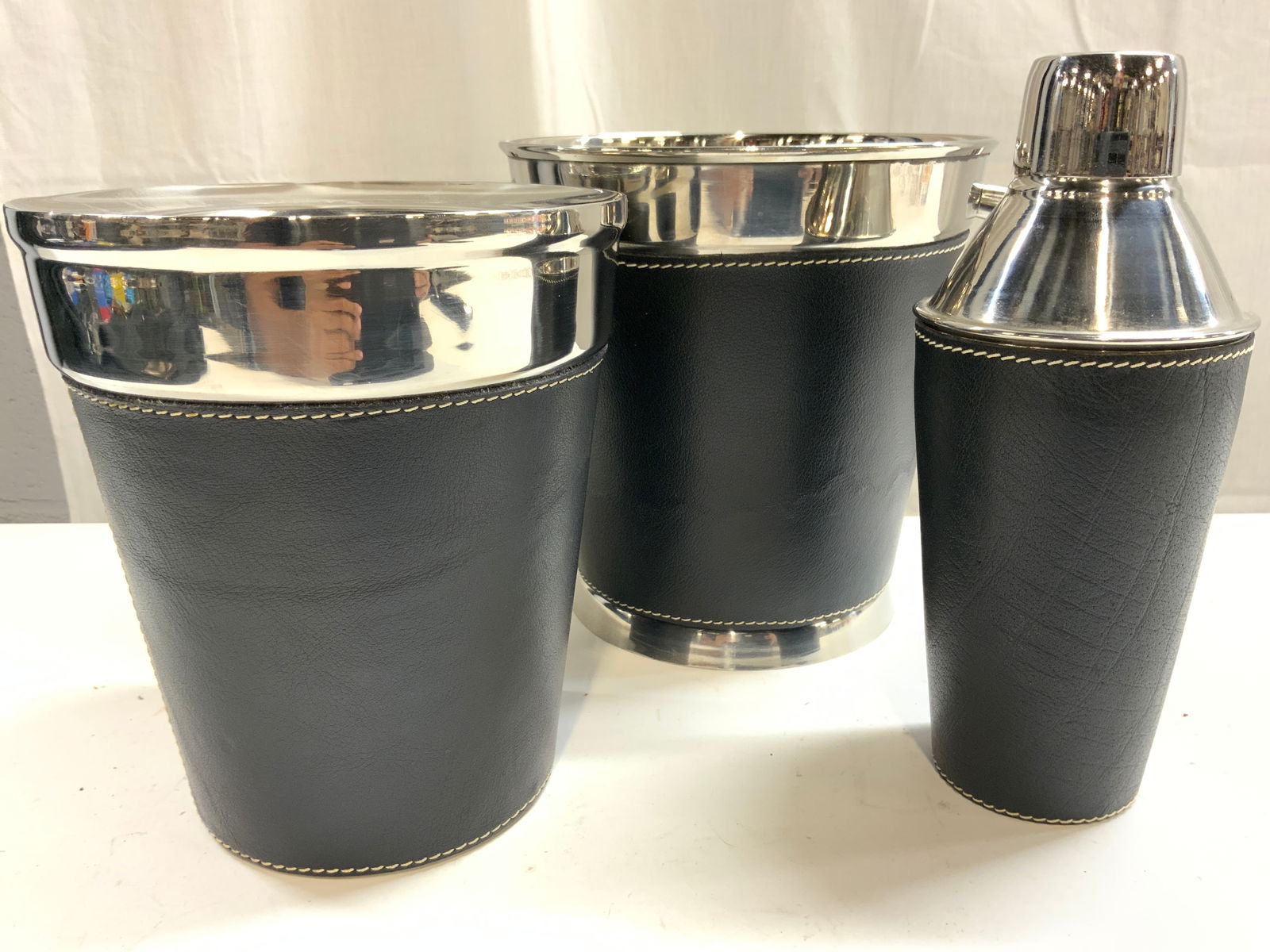 Stainless & Leatherette Shaker Ice Bckt & Wine Clr: Lot includes 1 cocktail shaker with lid, 1 ice bucket, & 1 wine cooler. Each piece is stainless and lined in black toned leatherette with white stitching. Sides of ice bucket have knob style handles.