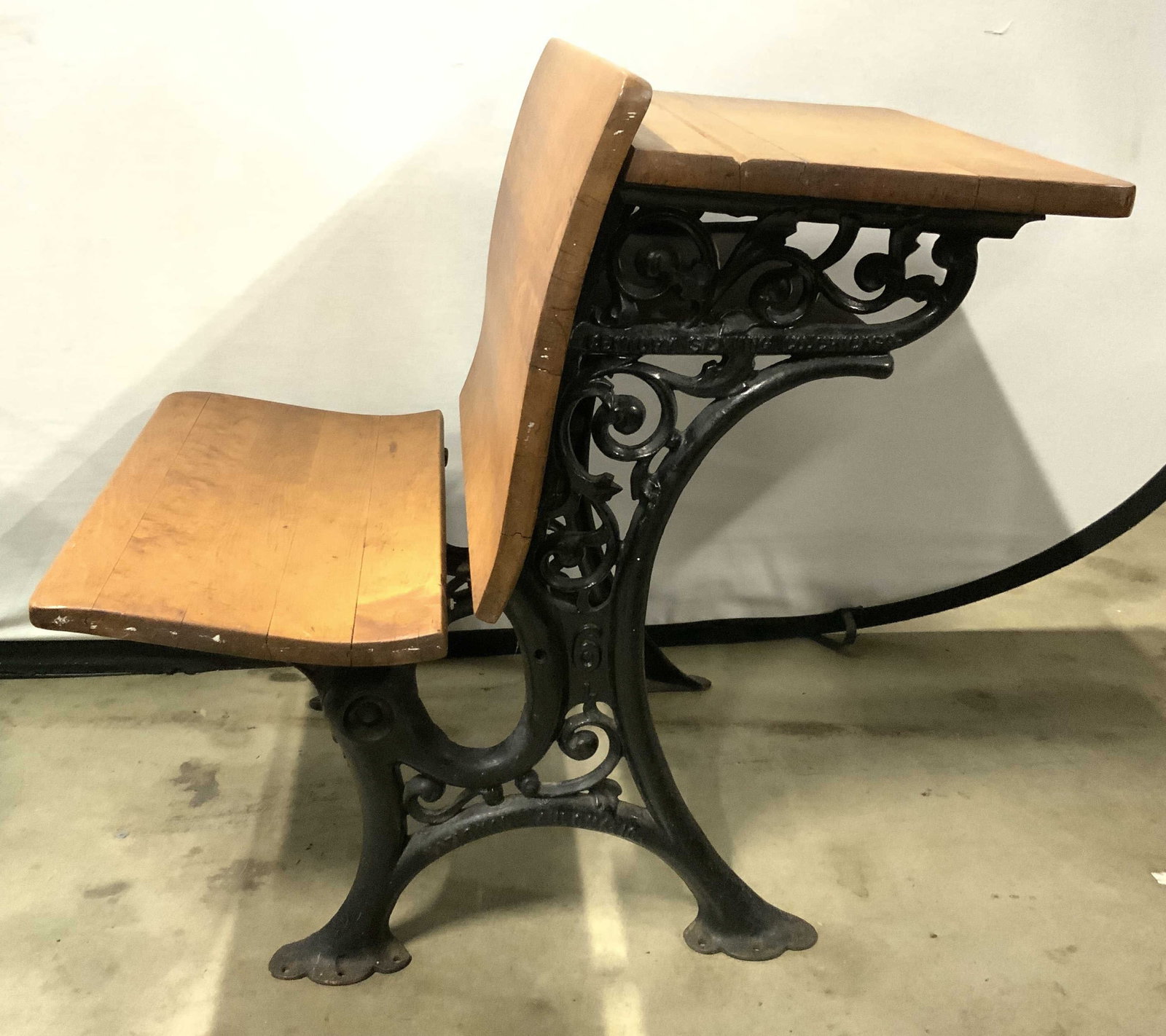 CENTURY SEATING CO Vtg Wood & Iron Desk: Desk is trademarked CENTURY SEATING CO on iron structure. Desk is tan toned wood and black toned iron. Piece has scroll and leaf detail. Seat has desk surface behind seating areas. Desk measures appro