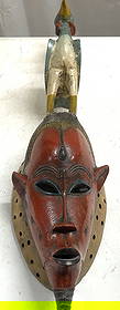 African Guro Mask From the Ivory Coast: Mask wall hanging appears to be and African Guro mask from the Ivory Coast. Piece is red with long slim beard area, facial features and zoomorphic bird figure on top of head. Piece is wooden. Appears