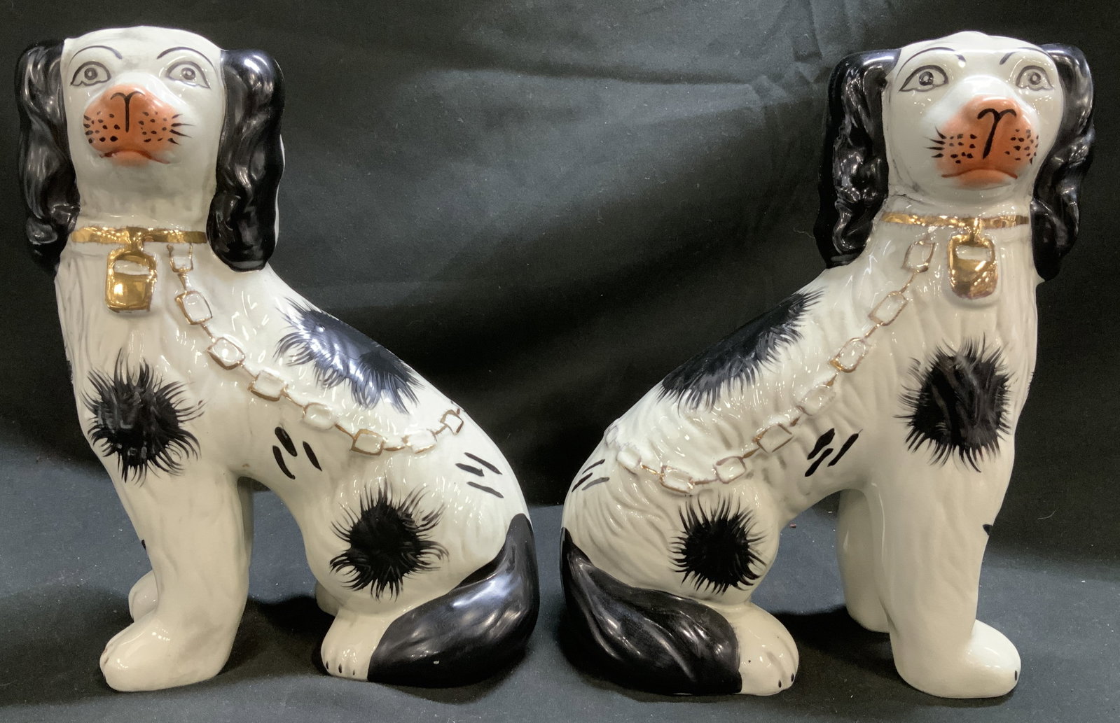 Repro Staffordshire Pair of Spaniel Dogs Figs.: Appears to be possible STAFFORDSHIRE reproductions. Depicts spaniel dogs in sitting positions. Spaniel dogs feature black spots & are wearing a gold-toned chain. No visible signature or markings. Surf