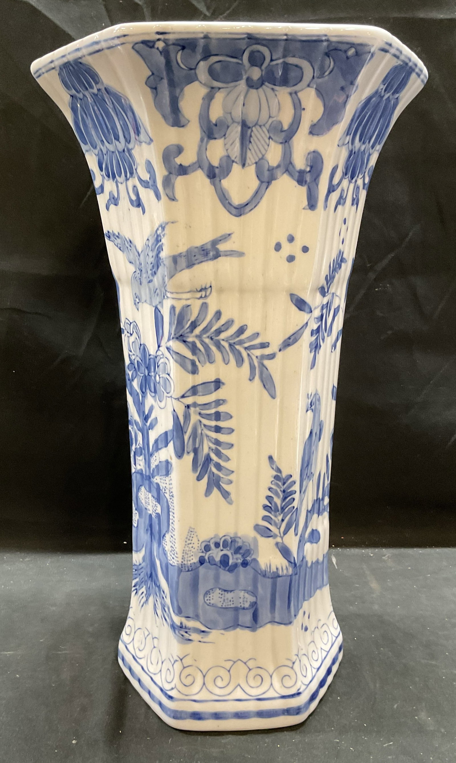 Bombay Company Porcelain Chinoiserie Vase 15In: Vintage Bombay Company porcelain vase. Hexagon shape with fluted rim. Hand painted blue and white with chinoiserie pattern. Birds and botanical motifs. Signed on underside. Measures approx 9 x 15 inch