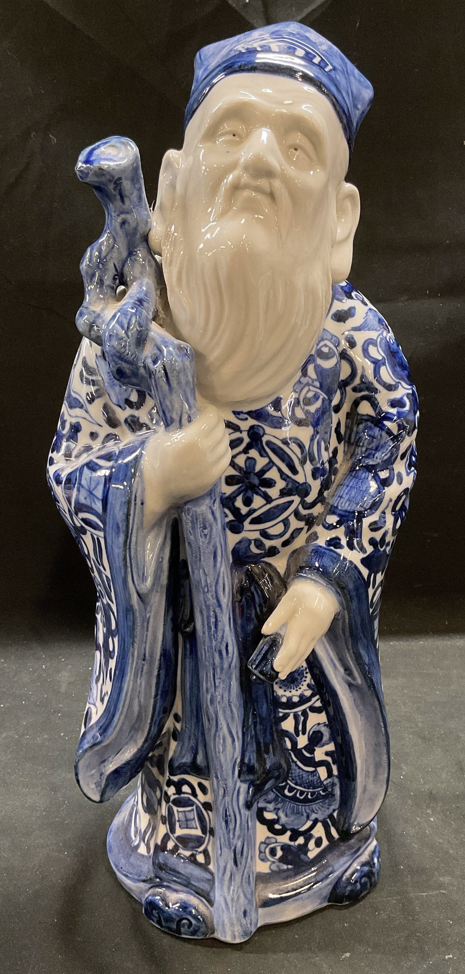 Signed Japanese Kutani Porcelain Jurojin Figurine: Signed Japanese Kutani porcelain figurine depicting Jurojin. God of wisdom and longevity. Elder man with beard holding staff. Hand painted in blue and white. Signed with stamp on underside. Measures a