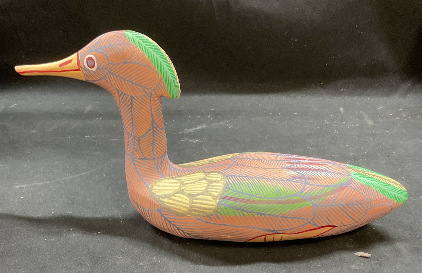 Hand Carved & Painted Wood Duck Decoy: Hand carved wooden duck decoy with hand painted decoration in pink, green, and yellow. Measures approx 11.5 x 3.75 x 5.75 inches. Some scratching and loss to paint. Decoy, duck decoy, wood duck, wood