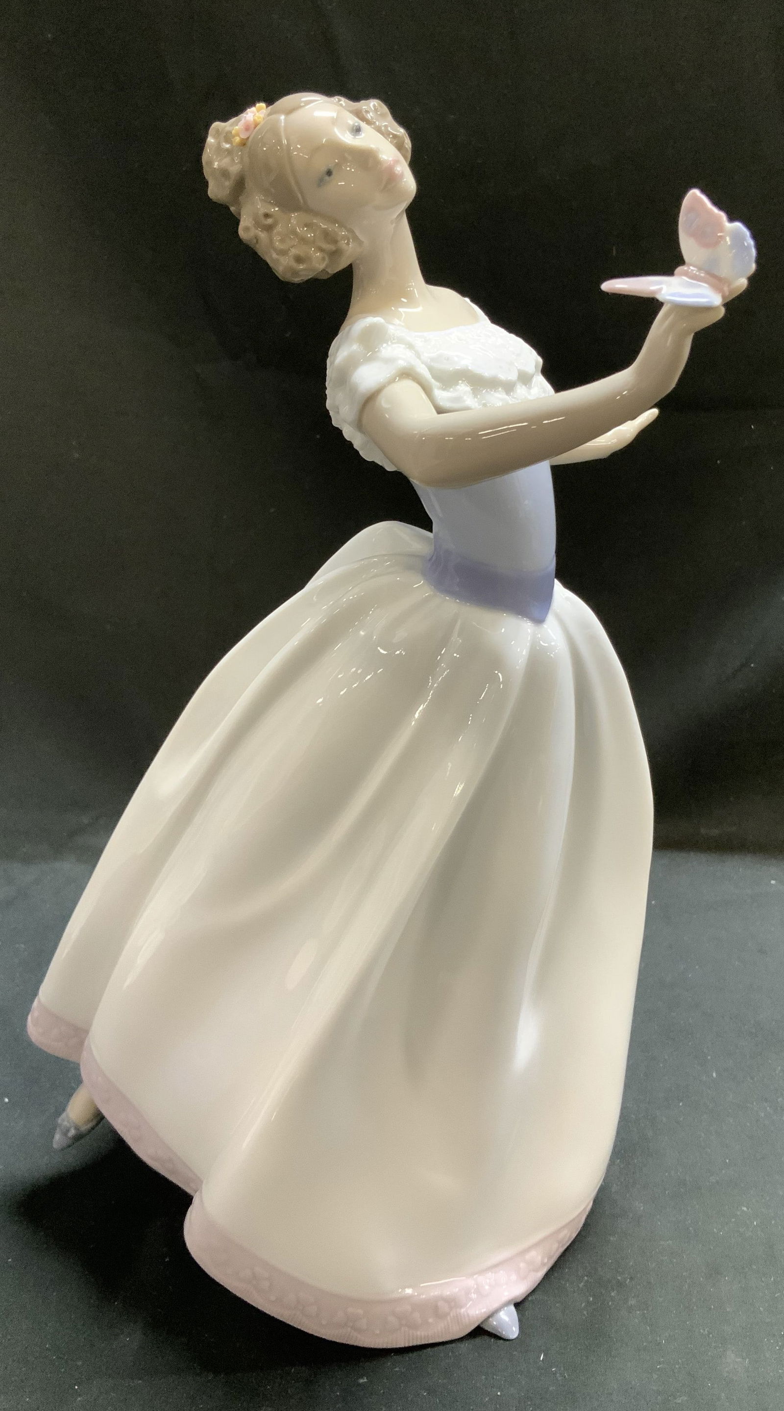 Lladro So Beautiful Porcelain Figurine SPAIN: Figurine depicts a young woman with her hair in a bun. She is wearing a long dress with a pale blue bodice & a white ruffled collar. Signed & marked on underside. Reads, LLADRO VWZ 94. HAND MADE IN SP