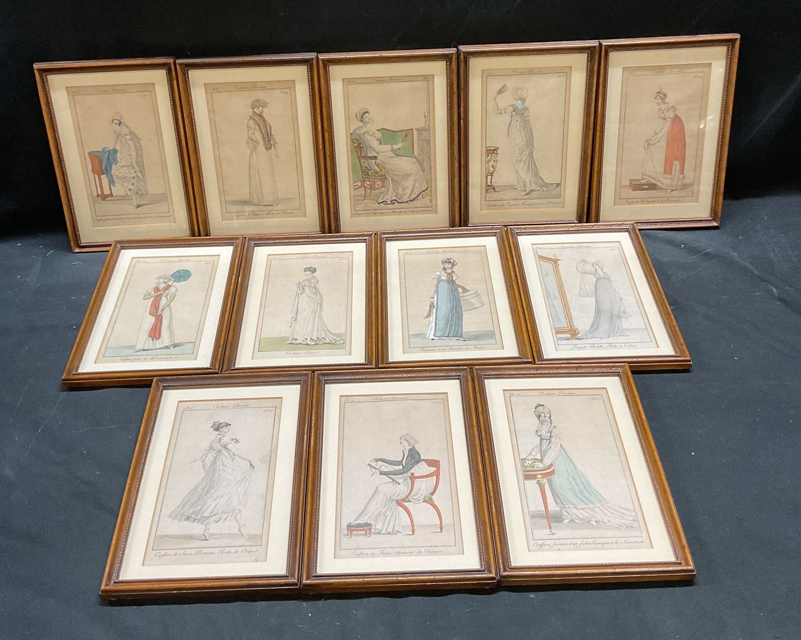Lot 12 Antq Costume Parisien Color Engravings: Lot of 12 antique framed and matted watercolor engravings on paper. All plates from Costume Parisien. Printed c. 19th century. Women in fashionable costumes. Wood frames. Not examined out of frames. F