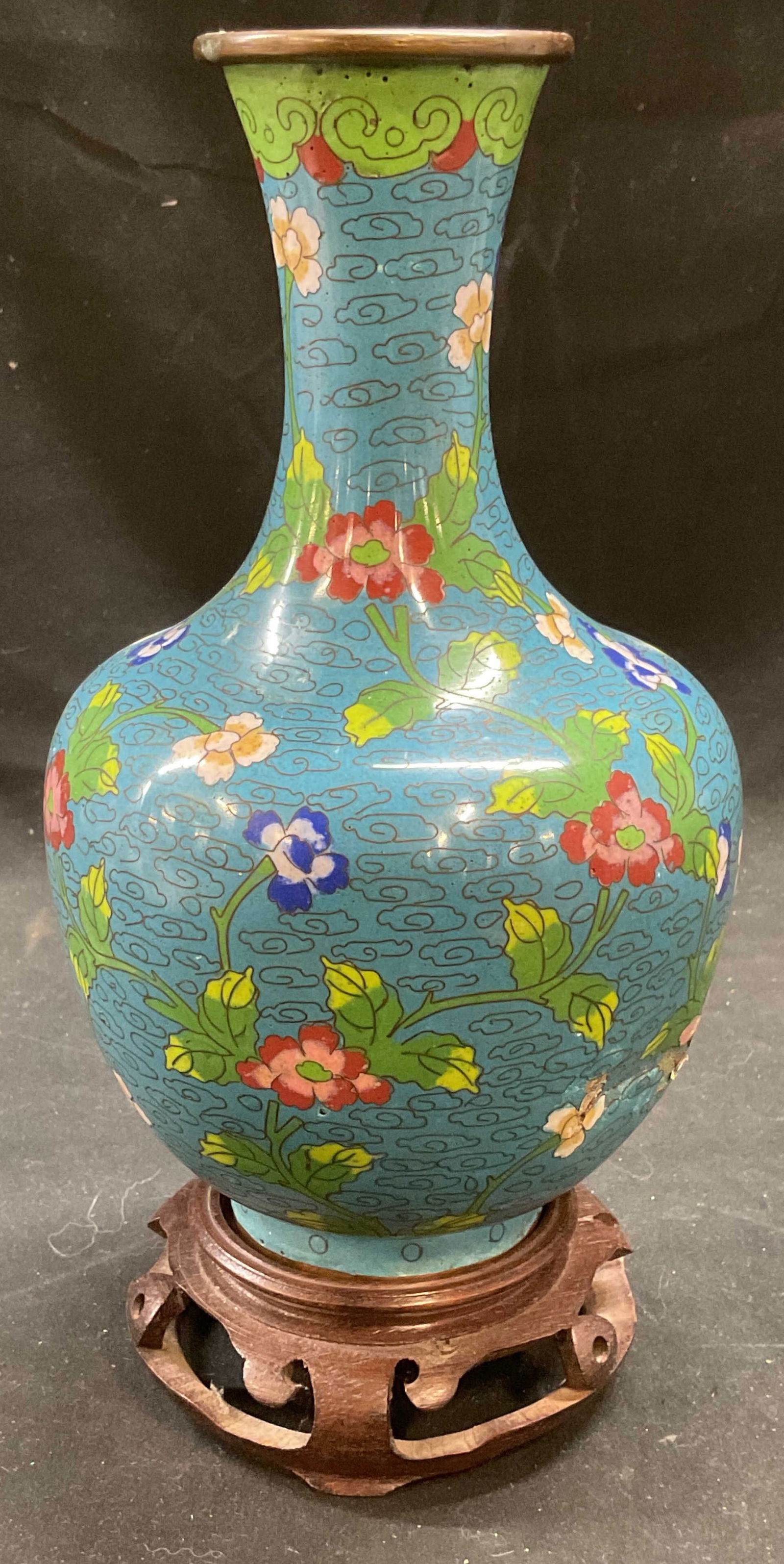 Vtg Chinese Cloisonne Blue Floral Vase & Stand: Vince Chinese cloisonne vase. Enamel over brass. Hand painted floral design in blue, red, and green. Measures approx 4.5 x 8.75 inches. Includes wood vase stand. Some scratching. Chinese vase, Chinese