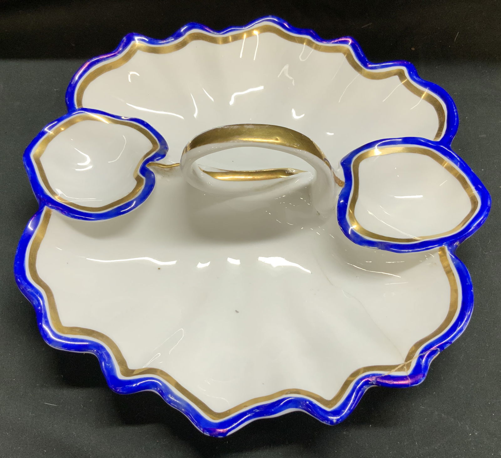 Antq KPM Leaf Shaped Serving Dish GERMANY: Antique piece from the Konigliche Porzellan-Manufaktur (KPM) in Berlin, Germany. Features a leaf shape w a central handle. Scalloped edges w cobalt blue & gold gilt accents. Porcelain material. Surfac