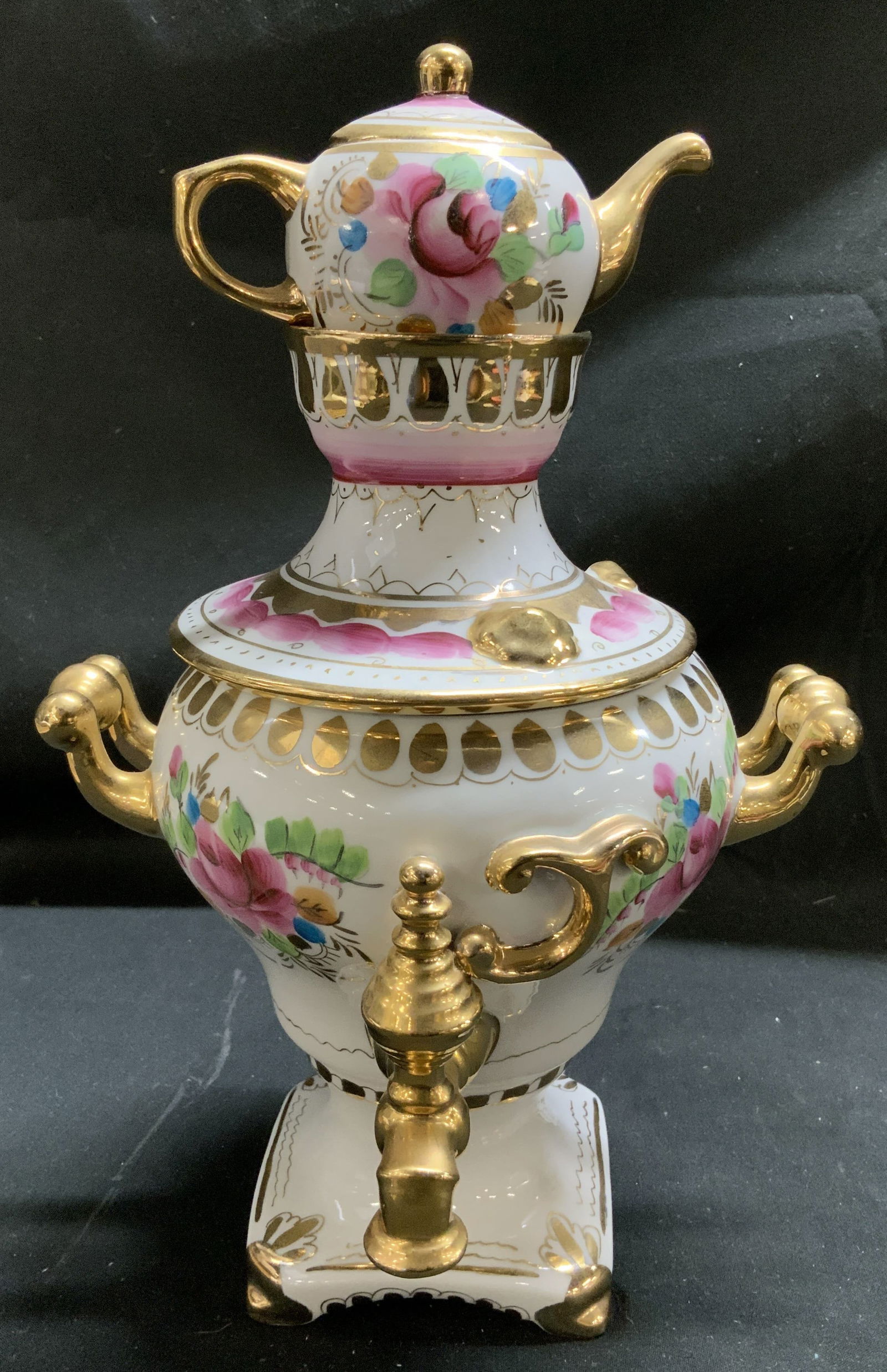 Sgnd Hand Painted Porc Samovar Set W Gilt Accents: Two piece porcelain samovar set featuring a lidded teapot resting atop a samovar base w ornate gilt handles. Hand-painted floral details. Signed on underside. Surface wear consistent to age, use & exp