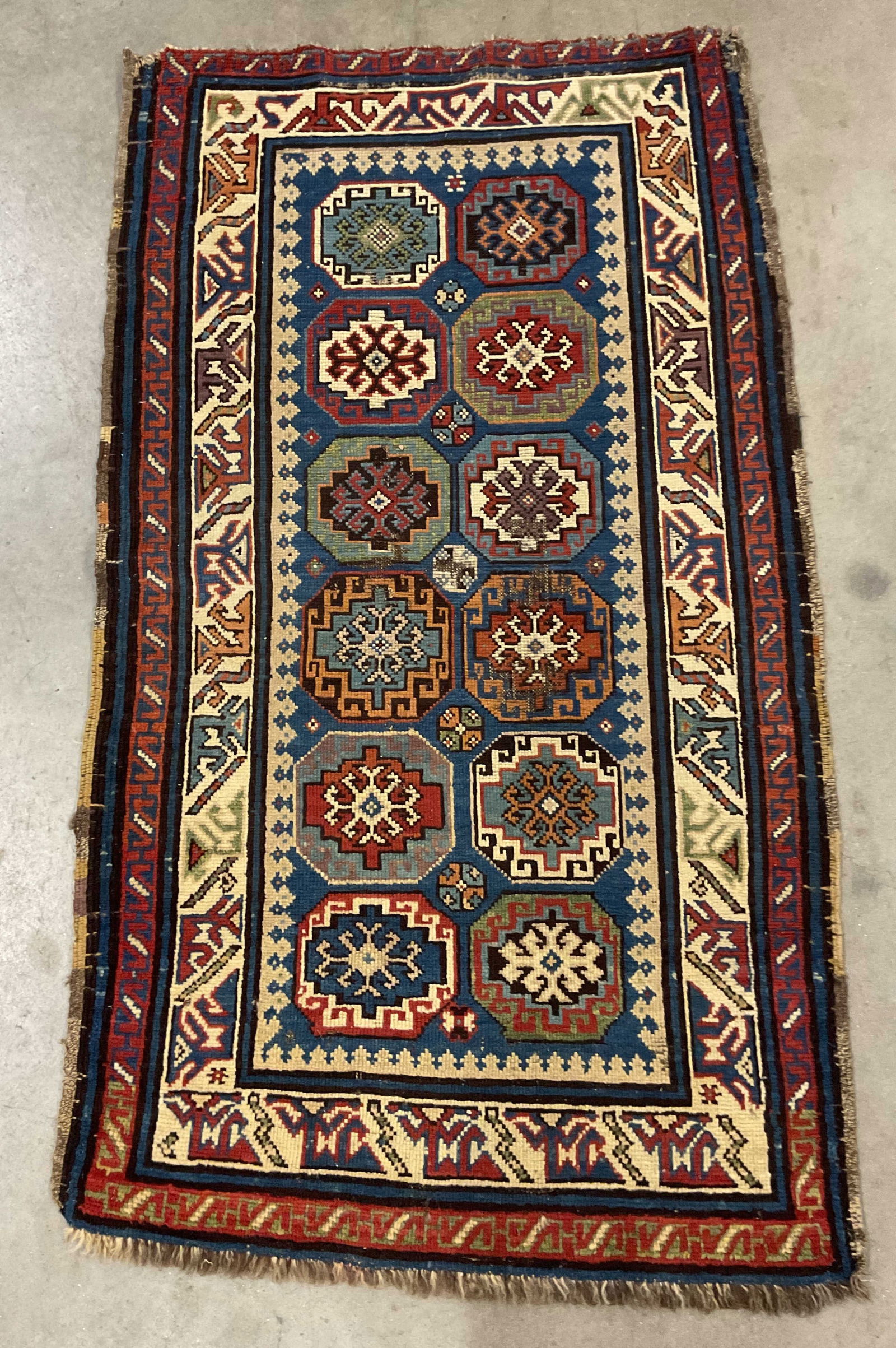 Antique Kazak Medallion Wood Area Rug: Antique Kazak wool area rug with medallion pattern and intricate geometric border. Red, blue, green. Measures approx 60 x 34 inches. Some losses and discoloration. Rug, antique rug, area rug, Kazak ru