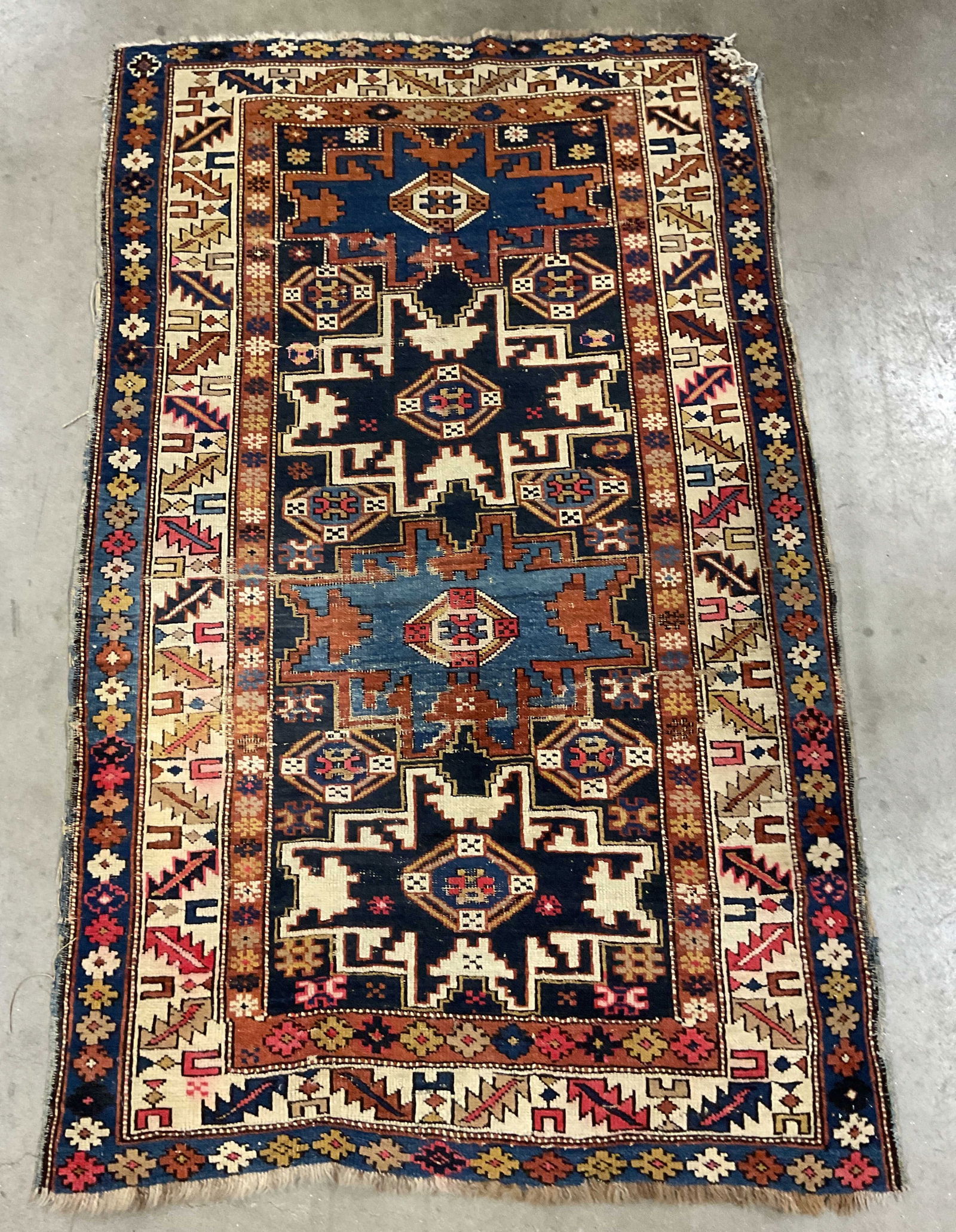 Antique Kazak Medallion Wool Area Rug 56 In L: Antique Kazak wool area rug, medallion pattern with intricate geometric border. Blue, red, and beige. Measures approx 56 x 34 inches. Wear including losses and discoloration. Rug, antique rug, area ru