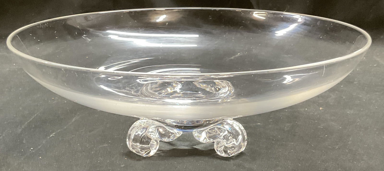 Steuben Art Glass Scroll Footed Bowl: Steuben Art glass bowl. Hand blown glass with applied feet. Scroll footed base. Signed on underside. Measures approx 11 x 3.75 inches. Some wear consistent with exposure. Steuben bowl, art glass bowl,