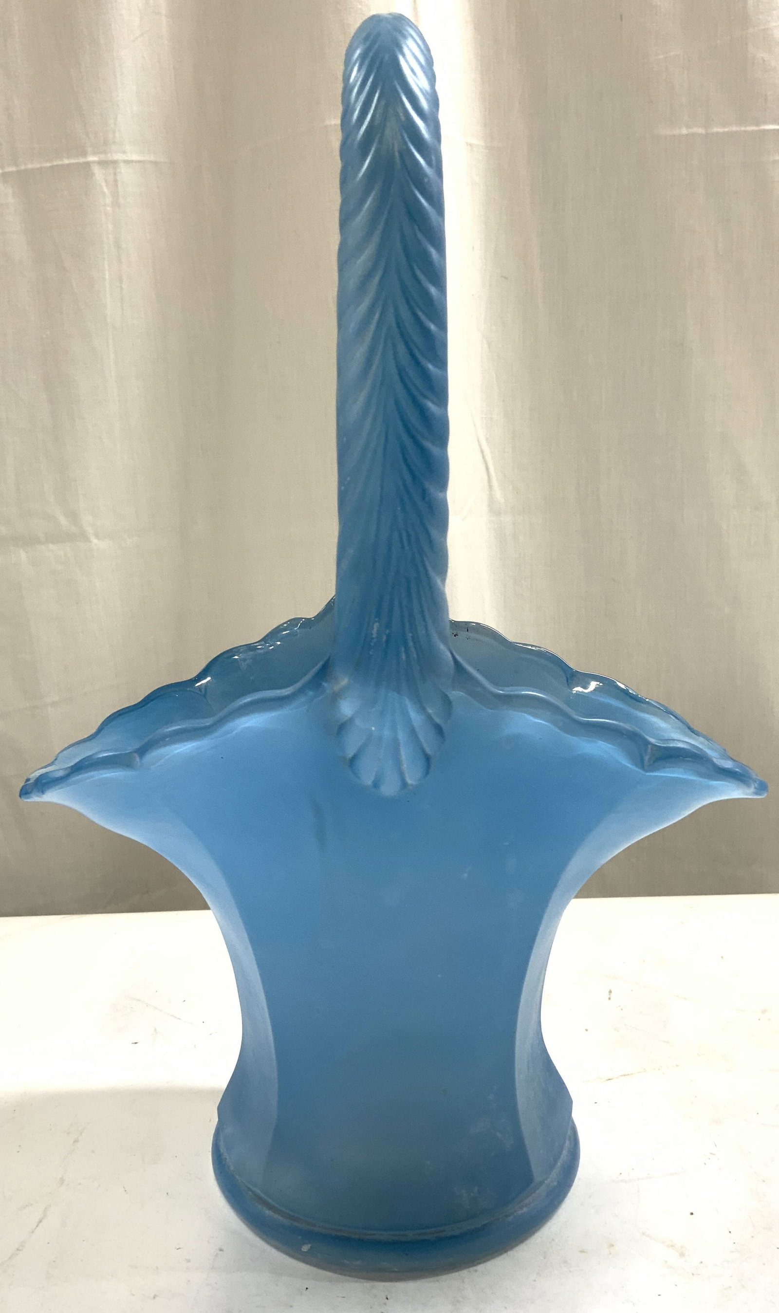 Westmoreland Blue Satin Glass Basket W Handle: Basket appears to be Westmoreland Glass (no apparent markings). Piece is light blue toned and frosted. Basket has arch form handle with relief detail. Basket has wavy rim. Piece measures approximately