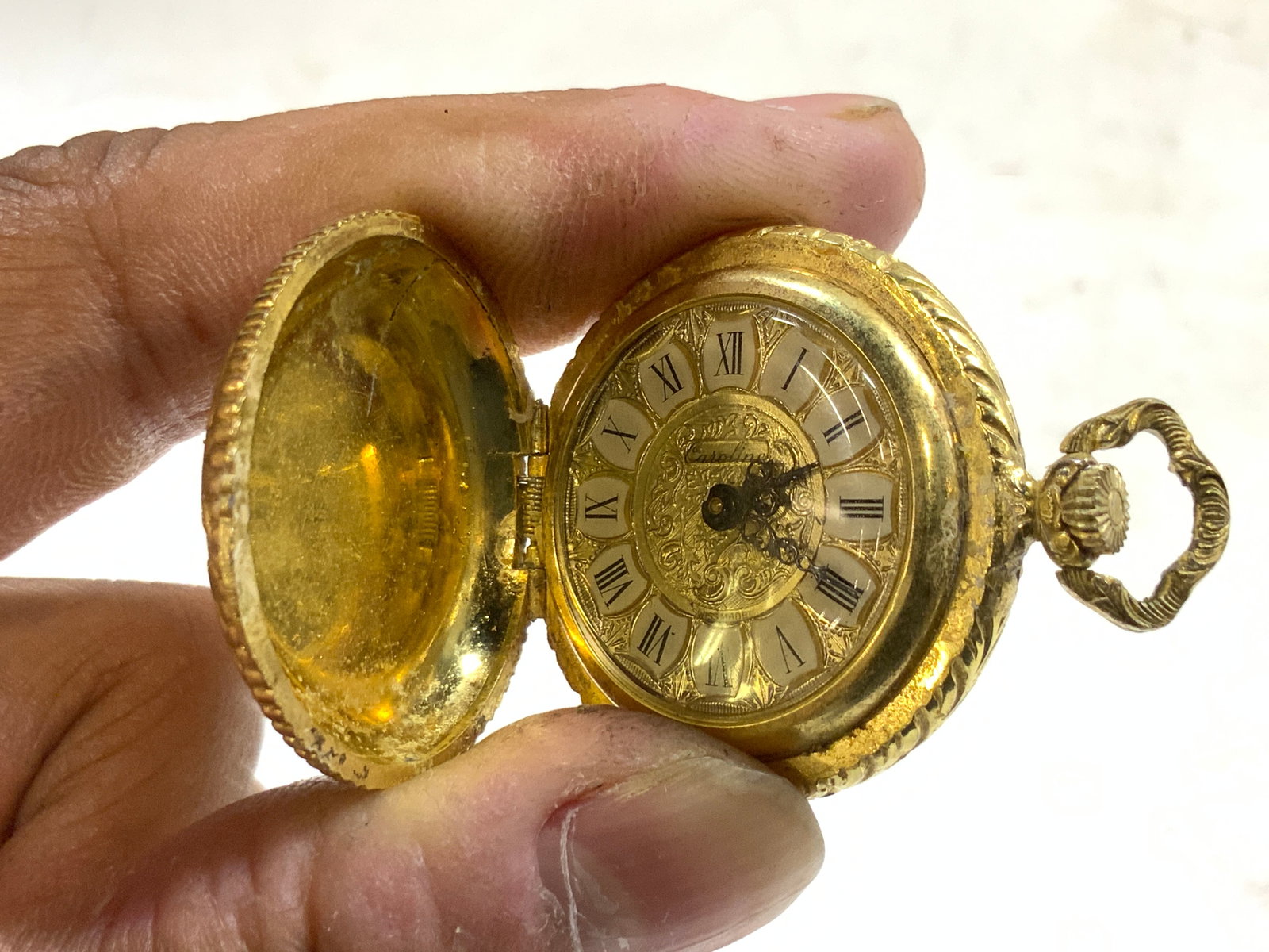 CAROLINE Vtg Gilt Metal Womens Pocket Watch: Pocket watch face reads CAROLINE. Piece is gilt metal. Exterior has ornate floral, scroll & leaf relief detail. Face has black toned Roman numerals and hands. Piece is vintage. Measures approximately 
