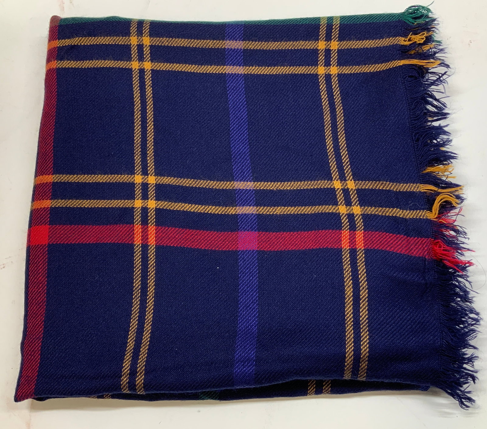 Vntg Specialty House Plaid Acrylic Shawl JAPAN: Shawl features a navy blue background with a plaid pattern of yellow, red, blue, and green stripes. Fringes on ends. Signed & marked. Reads, 100% Acrylic. Specialty House. Made in JAPAN. Surface wear 